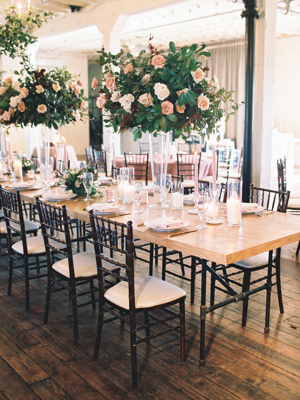 Tall peach &amp; orange flower centerpieces with greenery at a indoor Texas Wedding