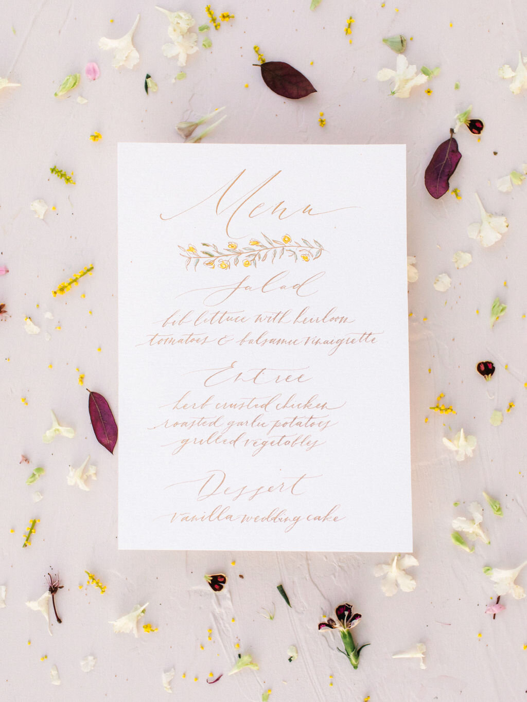 Calligraphy menu with gold text &amp; outline flower designs with filled in yellow