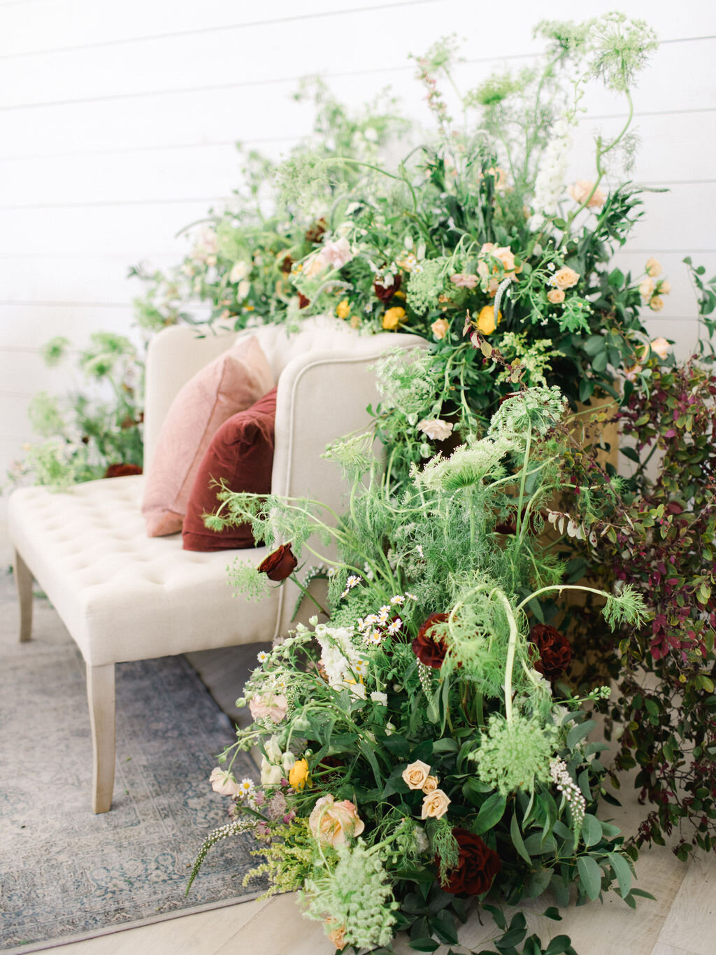 Wedding lounge seating in a greenery installation