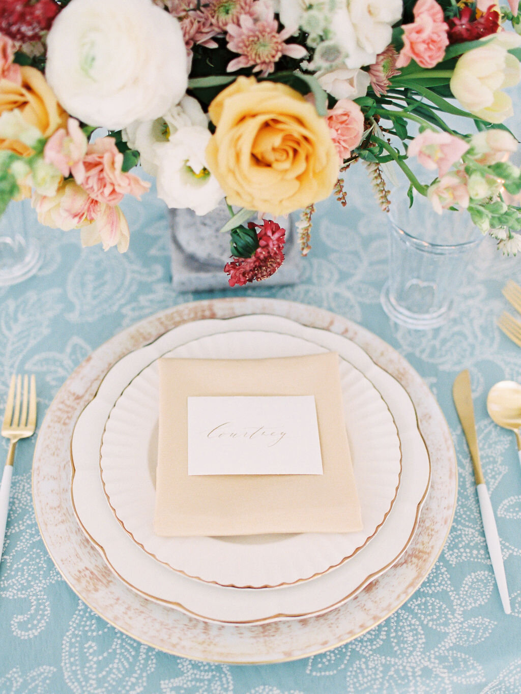 Place setting with a yellow napkin and place card on a light blue linen