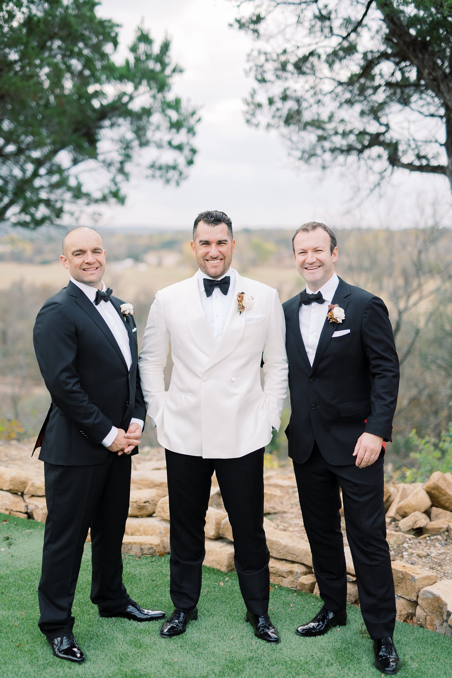 Groom in white jacket tux and groomsmen in black tux