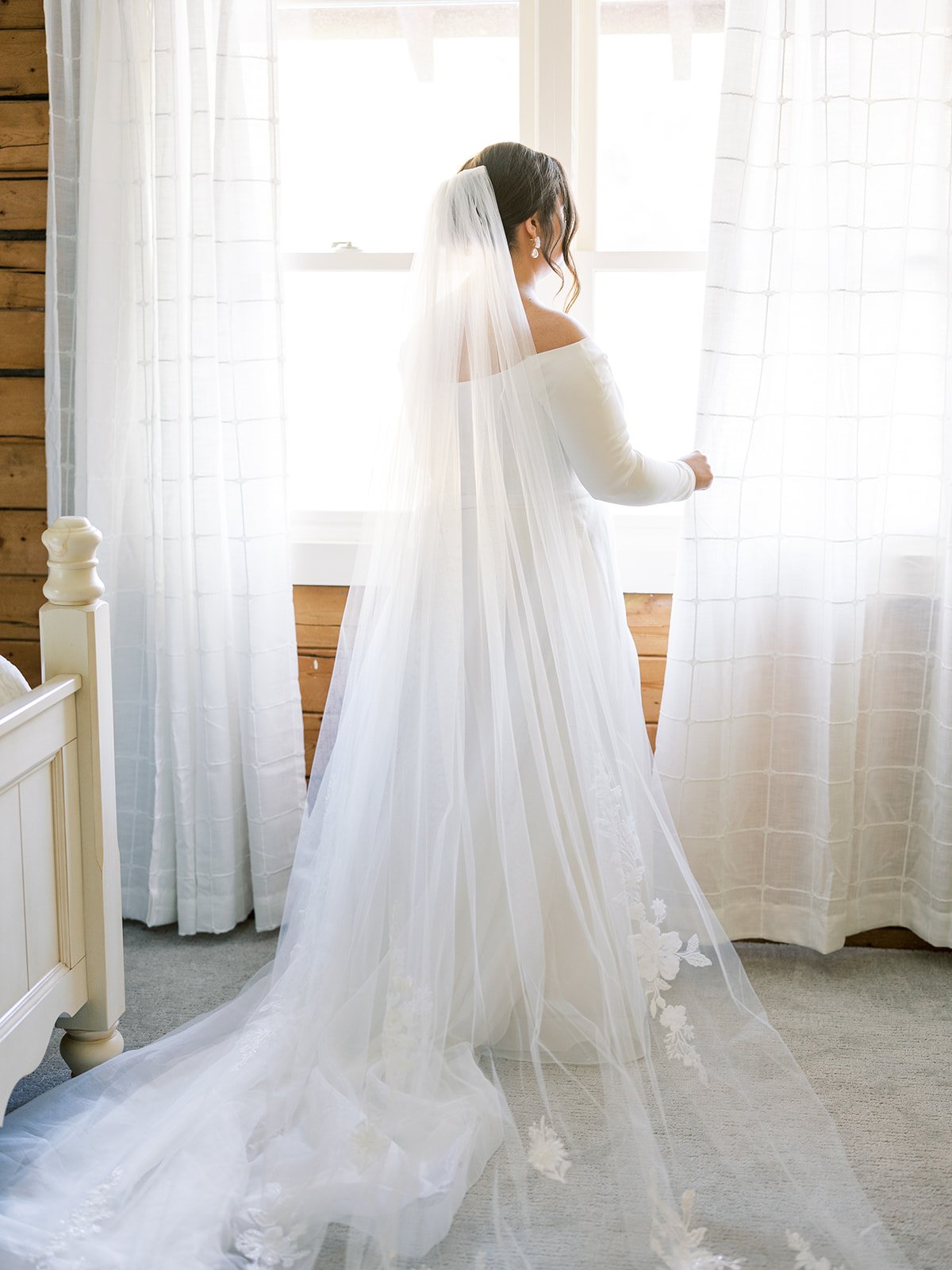 Bride standing by window in cabin
