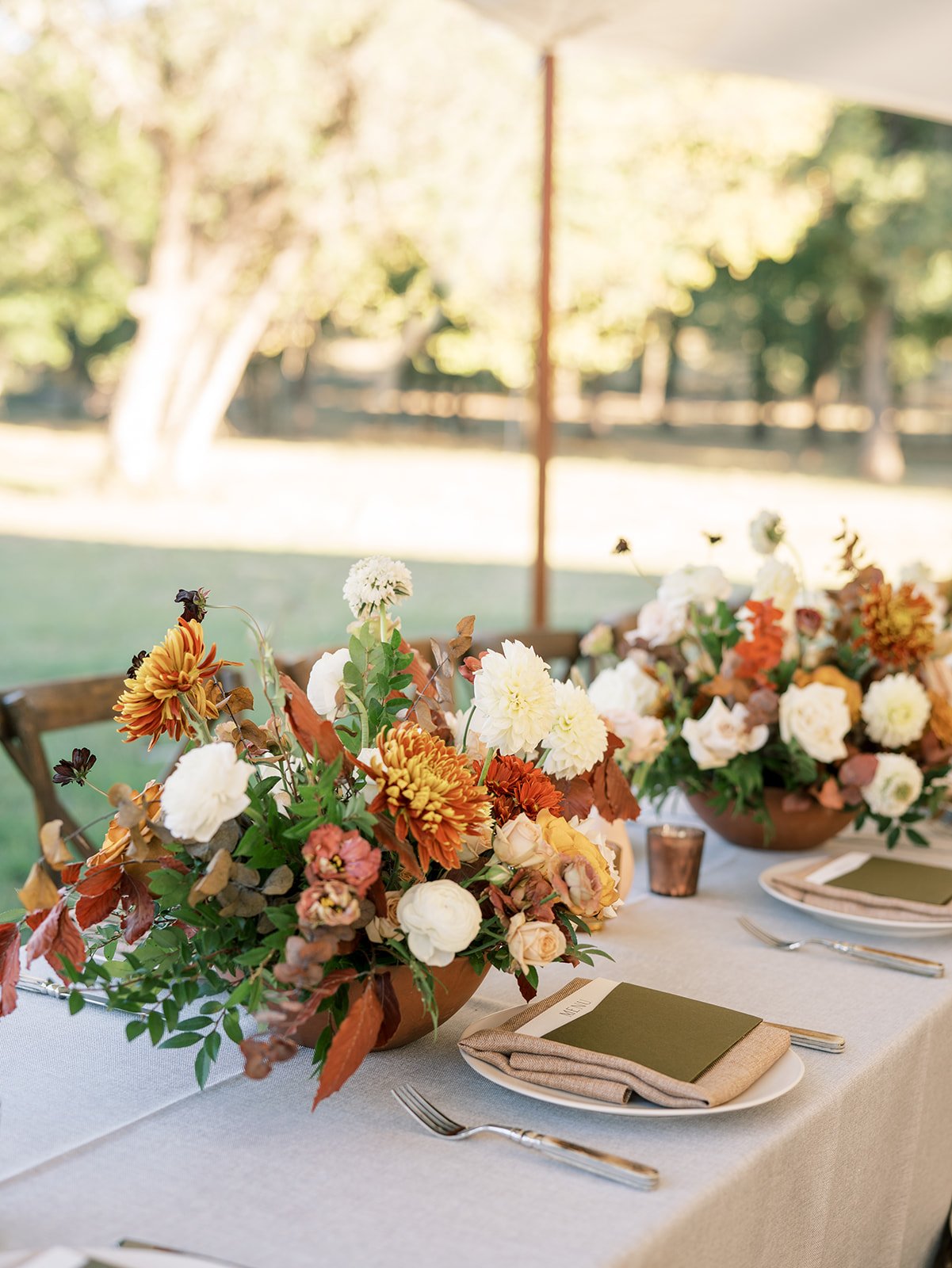 Long wedding table with red orange and white flowers at sailcloth wedding reception by Shannon Rose Events