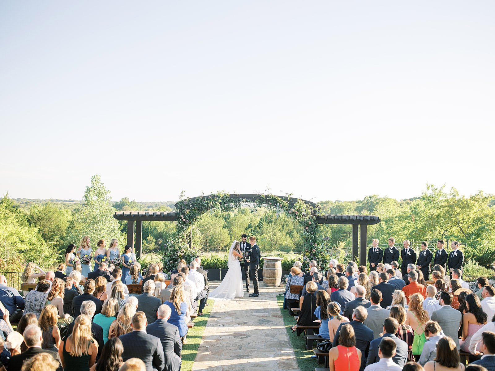 Outdoor wedding ceremony with large wood archway