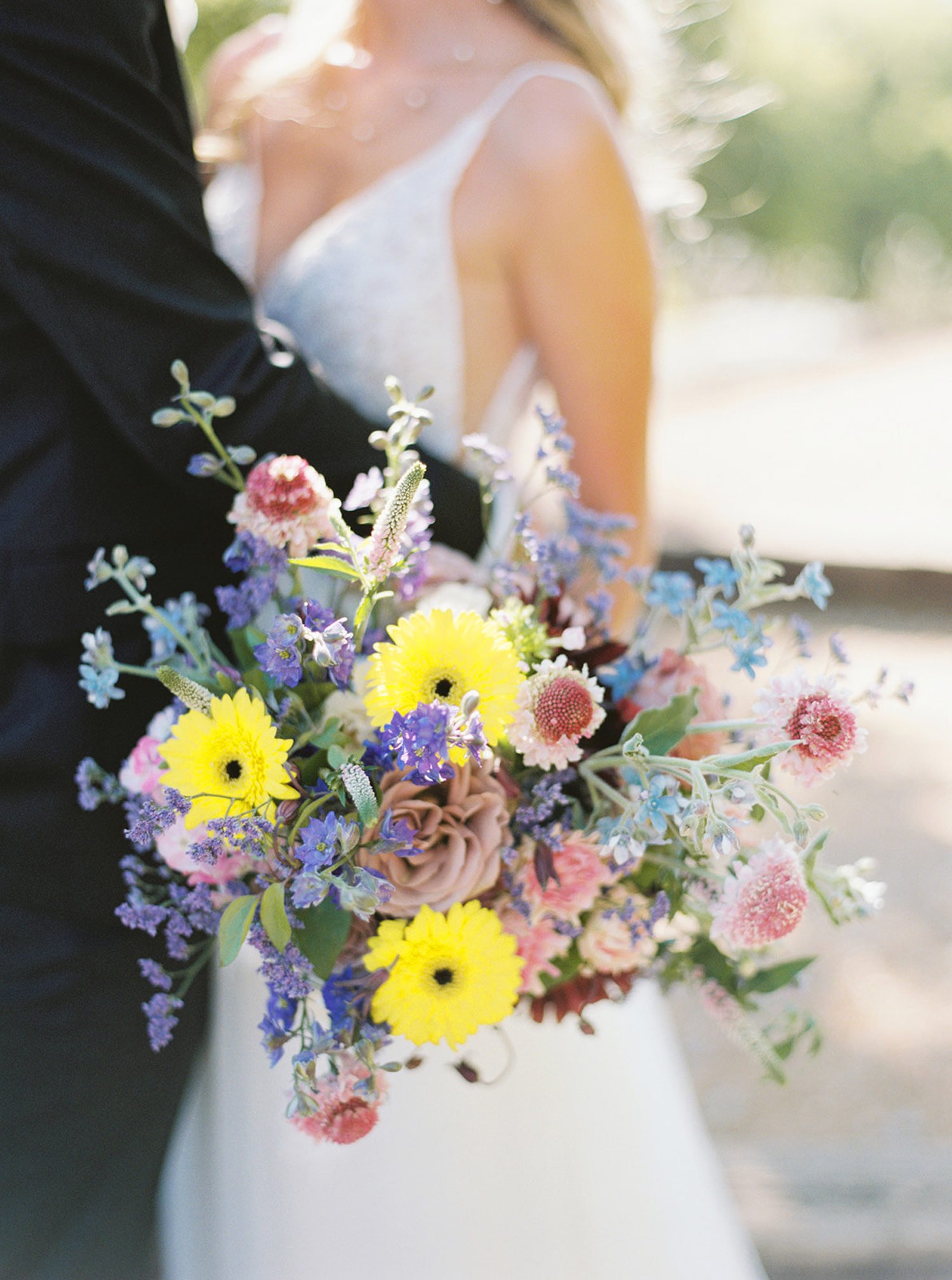 Lush wildflower wedding bouquet with yellow purple blue flowers designed by Montana wedding planner Shannon rose events