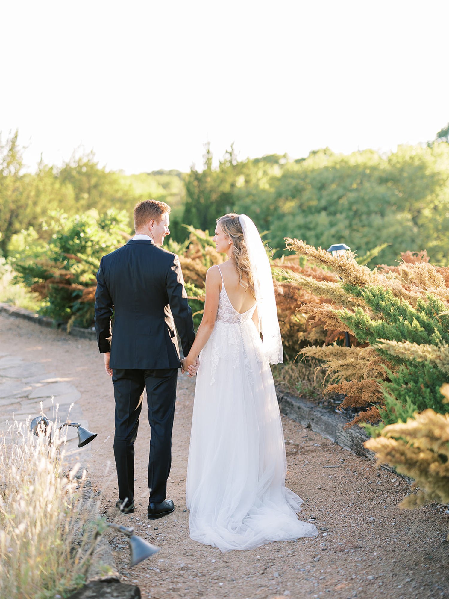 Bride and groom walking outdoor pathway at Stone Crest Venue