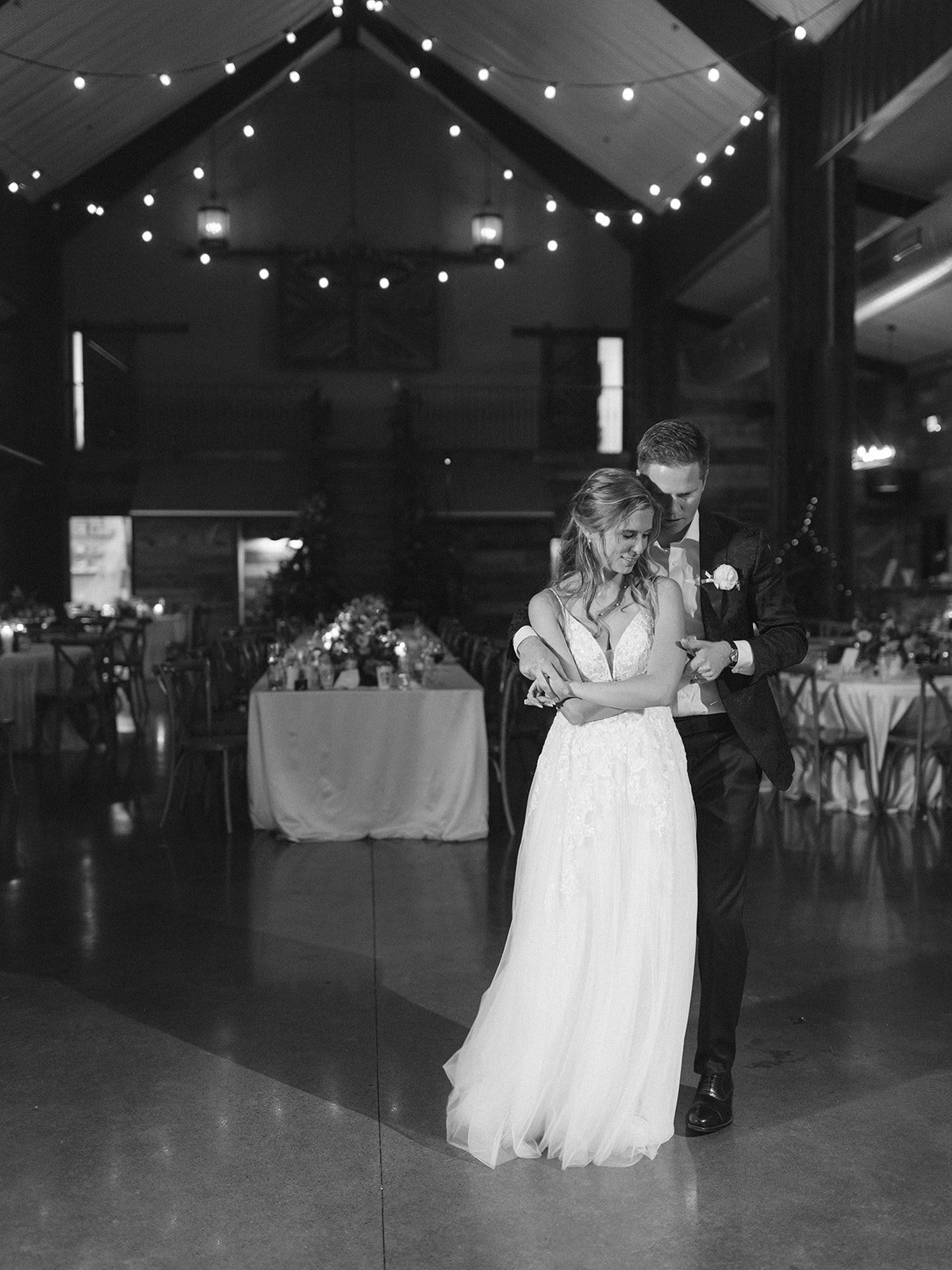 bride and groom dancing under bistro light at barn wedding by Shannon Rose events