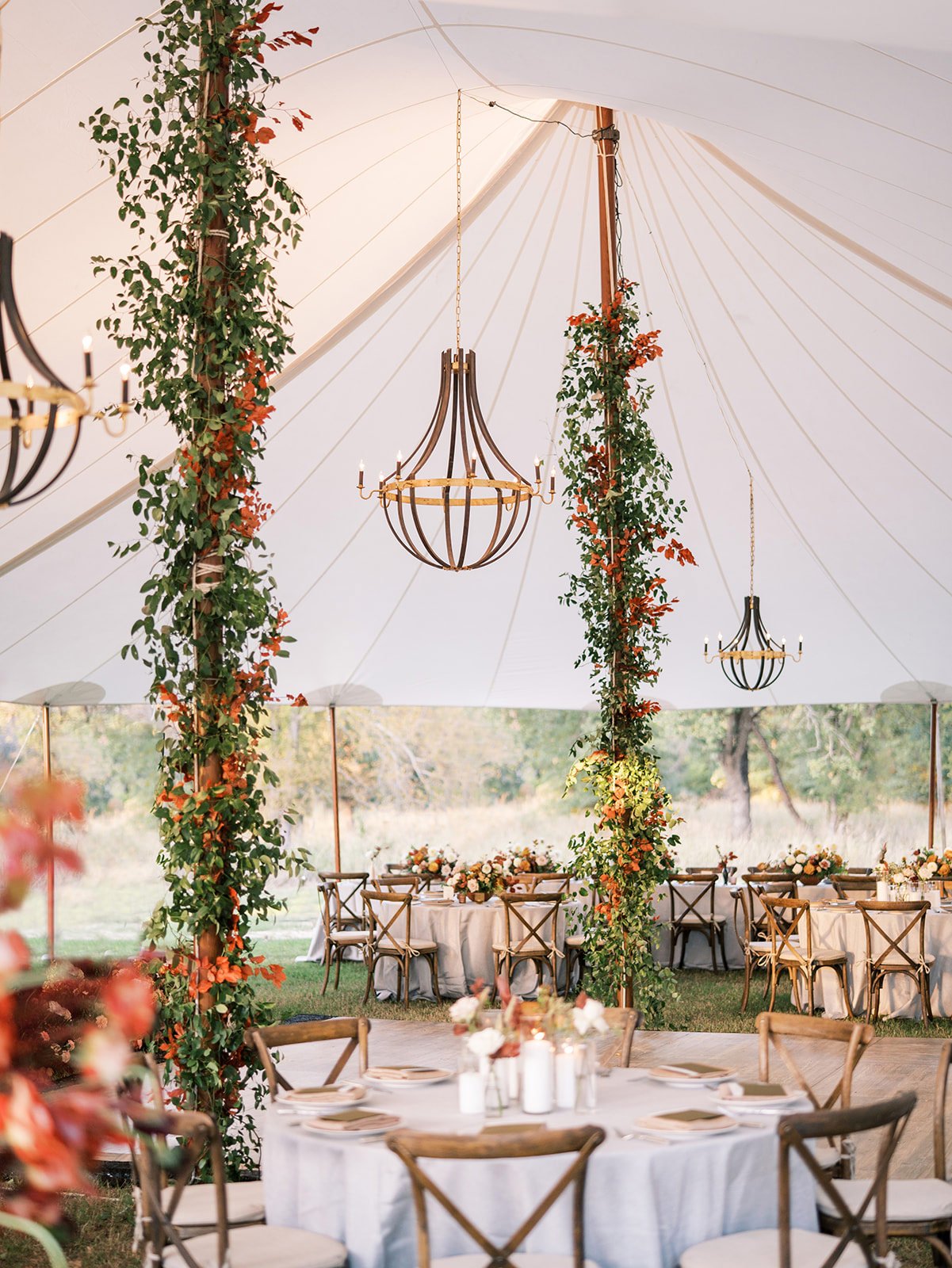 Sailcloth wedding tent with black chandeliers and greenery on posts designed by Ranch wedding planner Shannon Rose Events