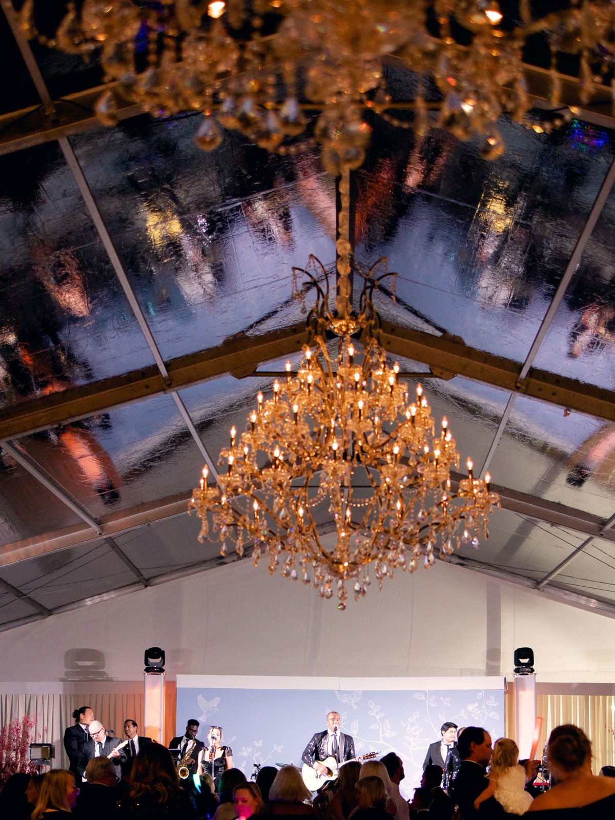 Elegant ranch Clear top tent wedding at night with a large chandelier