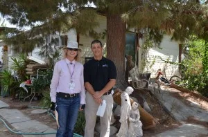 Mark Abbott and Anastasia Studer from the Riverside County Department of Environmental Health stand outside of a resident's home before collecting a sample from their new water treatment system