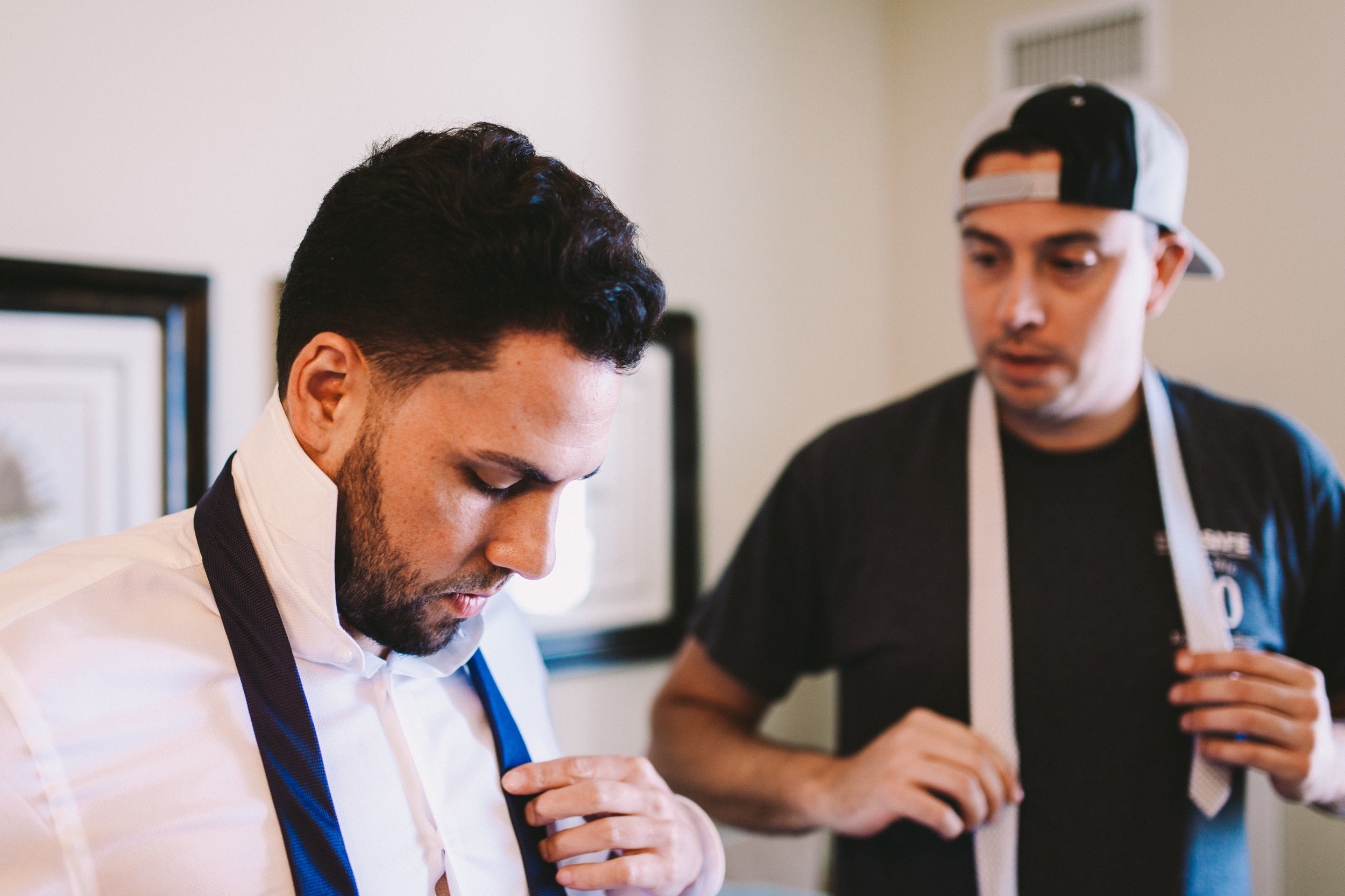Best Man Helping Groom Figure Out Hows to Tie a Tie