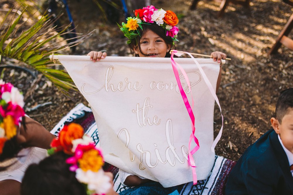 Colorful Flower Crown &amp; Flower Girl Holding 'Here Comes the Bride' Banner
