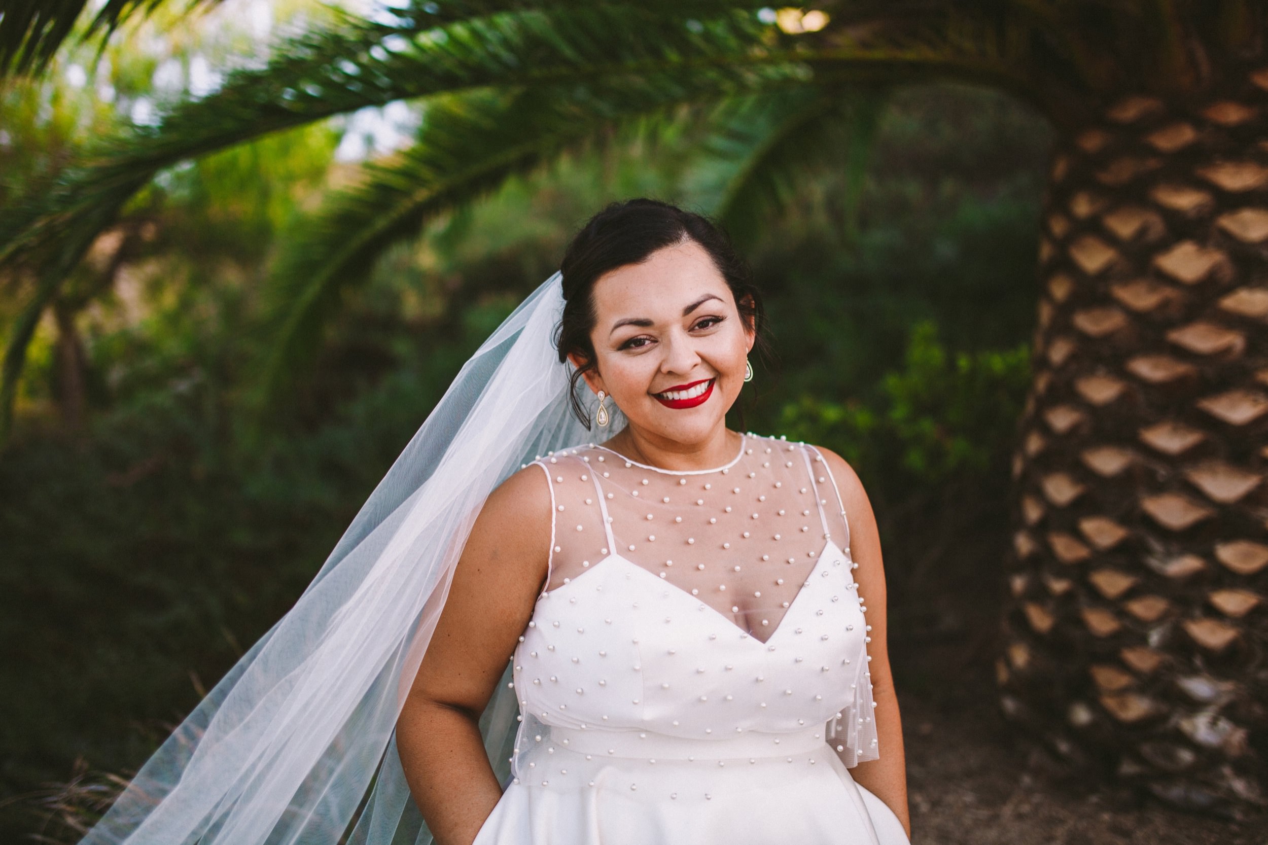 Beautiful Bride with Red Lipstick and BHDLN Separates in front of a Palm Tree