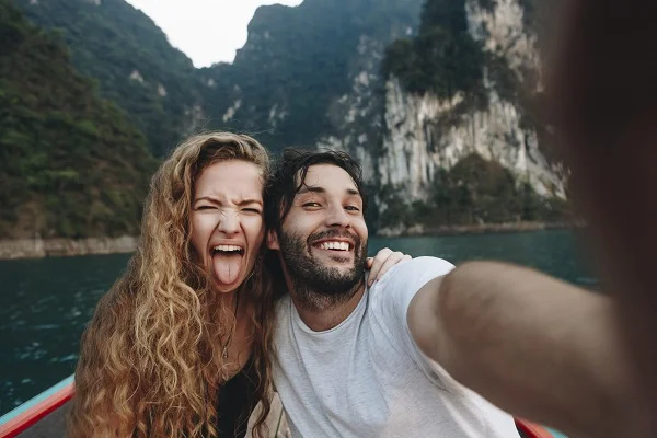 Happy man and woman on a boat in on a mountain lake.jpg
