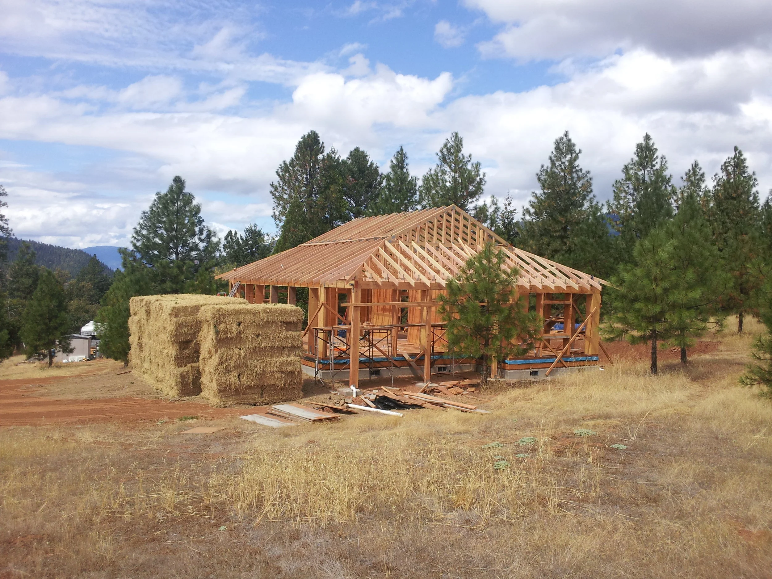 I-Joist or LVL type of post-and-beam system uses 3-string bales stacked on edge (15" wide) for maximum insulation value per inch of wall thickness. Uses straw bale shear wall and interior partition shear walls.