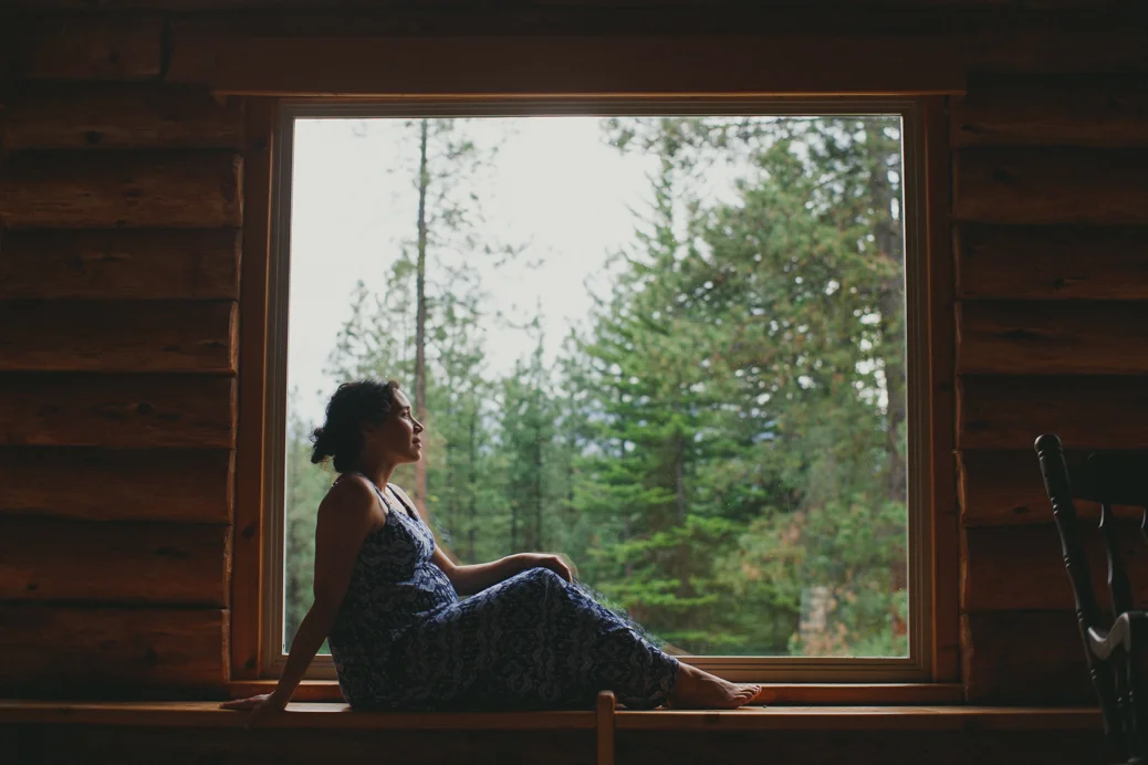 pregnant woman sitting in cabin window seat