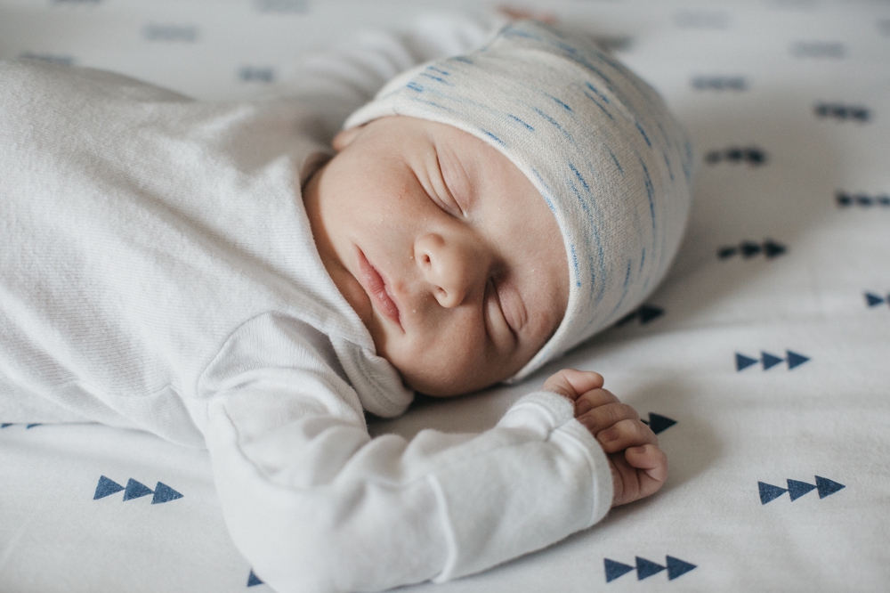 newborn sleeping on tree sheets