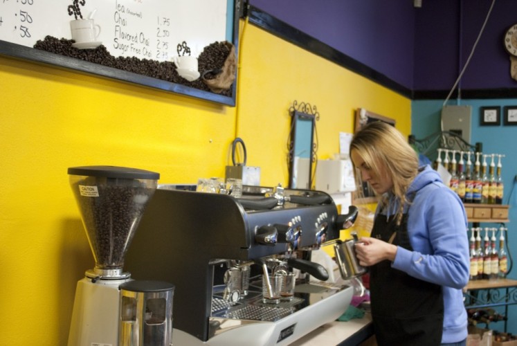 Junior Daysha Browne makes a drink in the on campus cafe, where students purchase coffee before school and at lunch time. Many of the drinks for sale contain the caffeine the students crave.