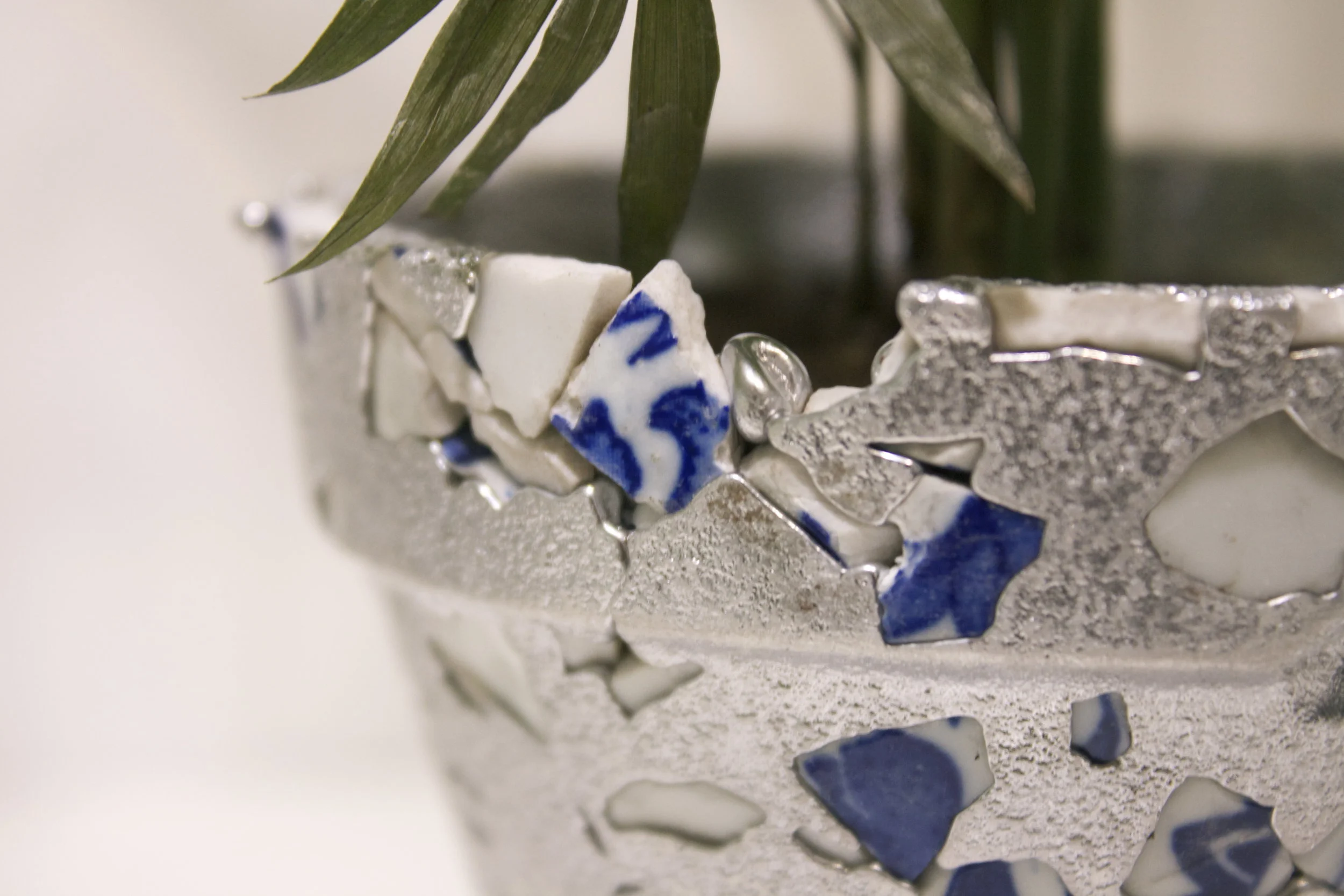 Recycled blue and white porcelain and recycled aluminum flower pots.