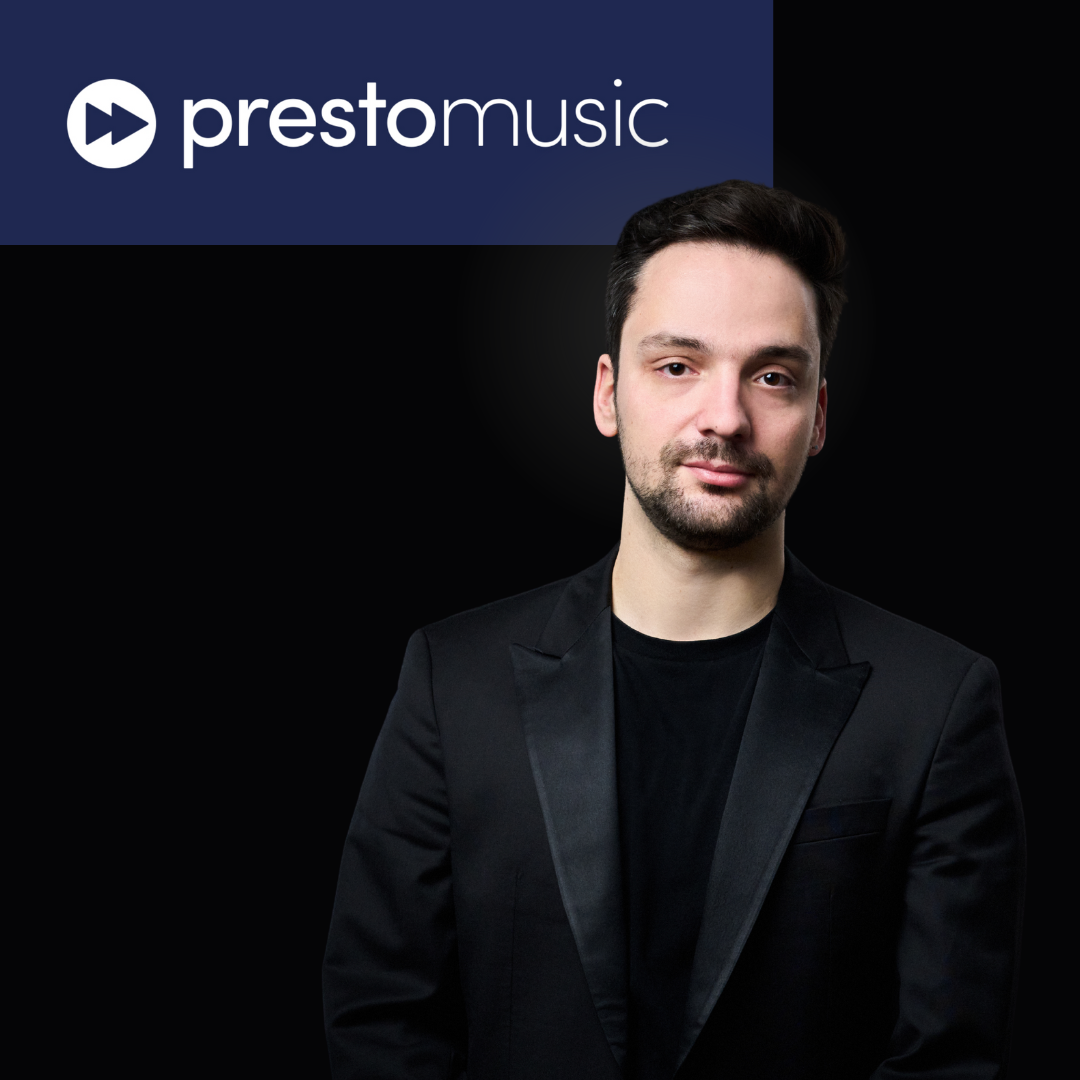 Promotional image with the Preston Music logo, a young man with dark hair and a beard wearing a black suit and shirt, standing against a black background.