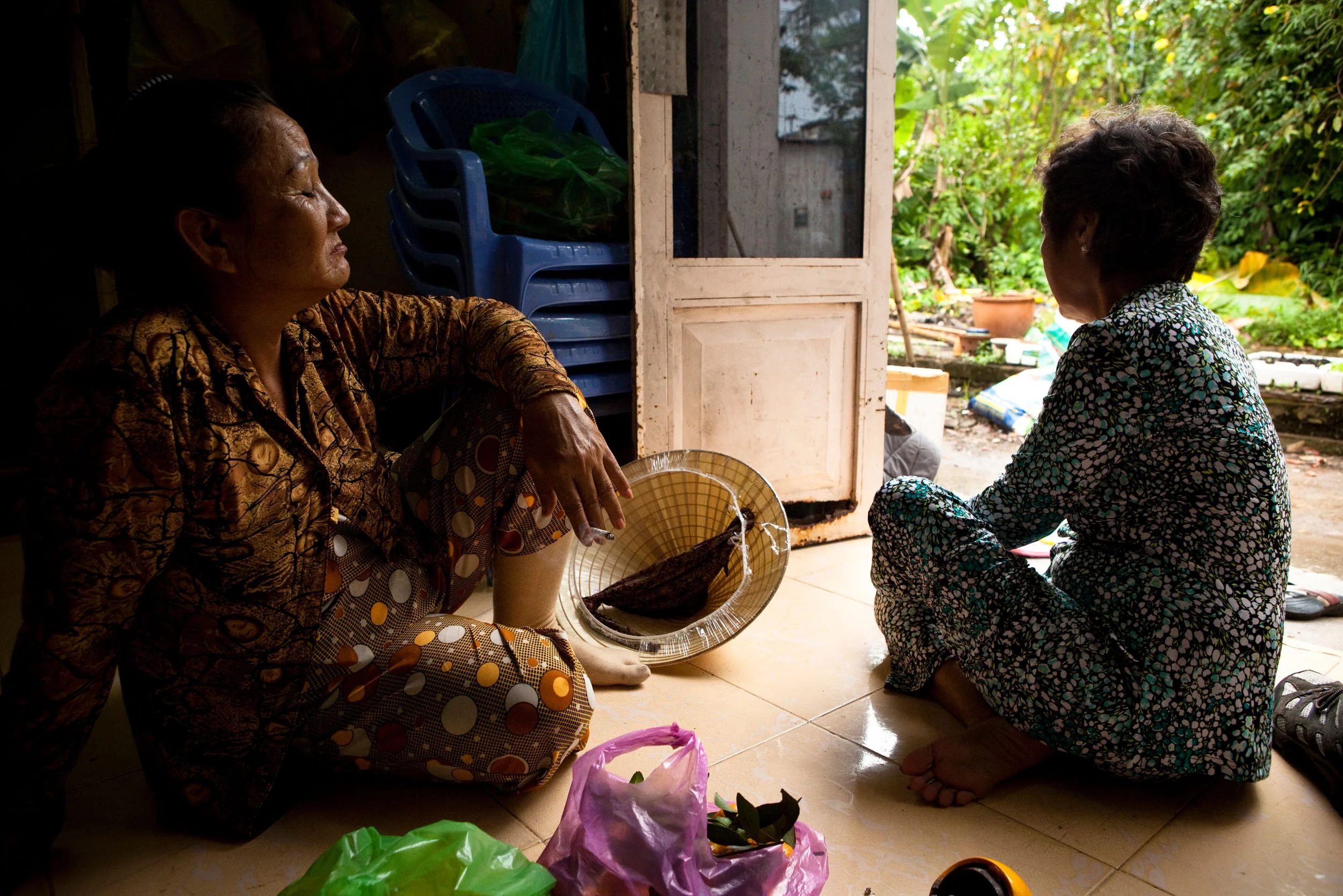 Hong lives alone in her home but her immediate family populates the neighborhood. Dang Thi-Kim Cue, her sister, keeps her company during the rain.