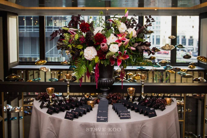 3-langham-wedding-steve-koo-photography-sweetchic-events-vale-of-enna-moody-romantic-wedding-black-escort-cards-tall-arrangement-black-vase-burgundy-wine-white