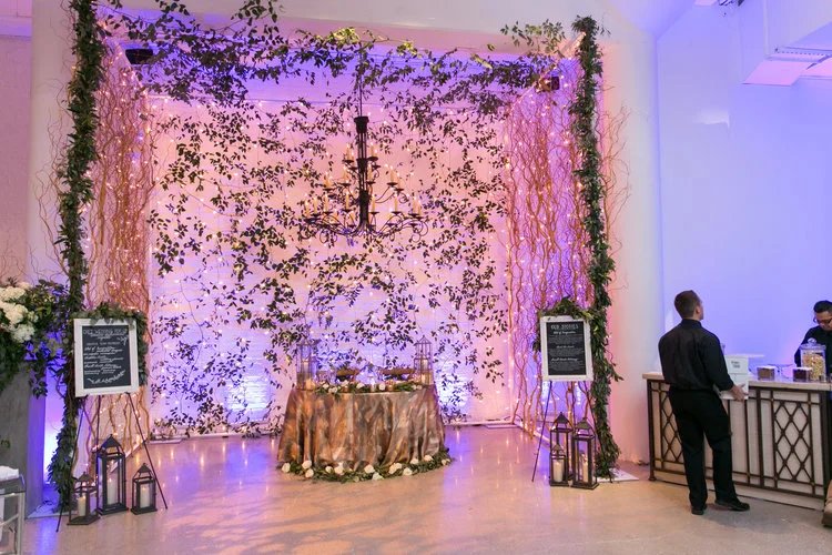 Dramatic ceremony arbor with greenery and curly willow