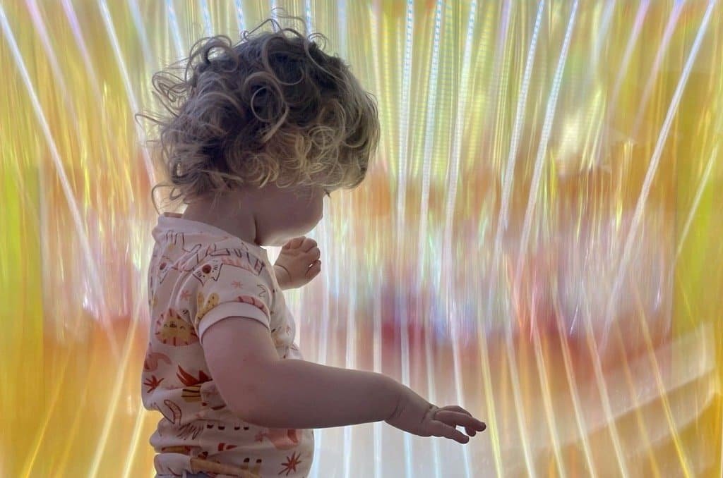 A child interacting with the dynamic lights of the sculpture.