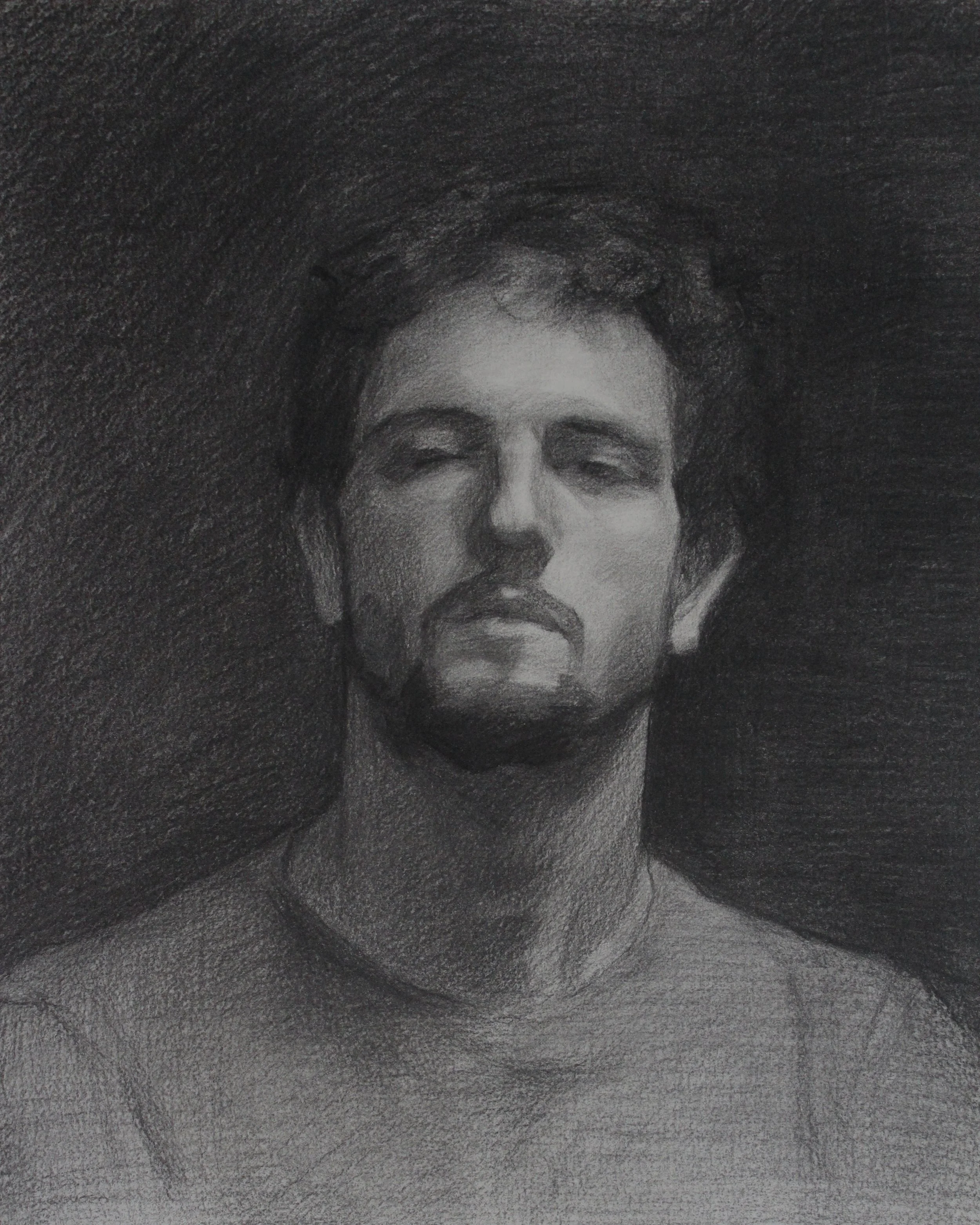 A black and white charcoal drawing of a young man with short, dark hair, closed eyes, and a serious expression, set against a dark textured background.