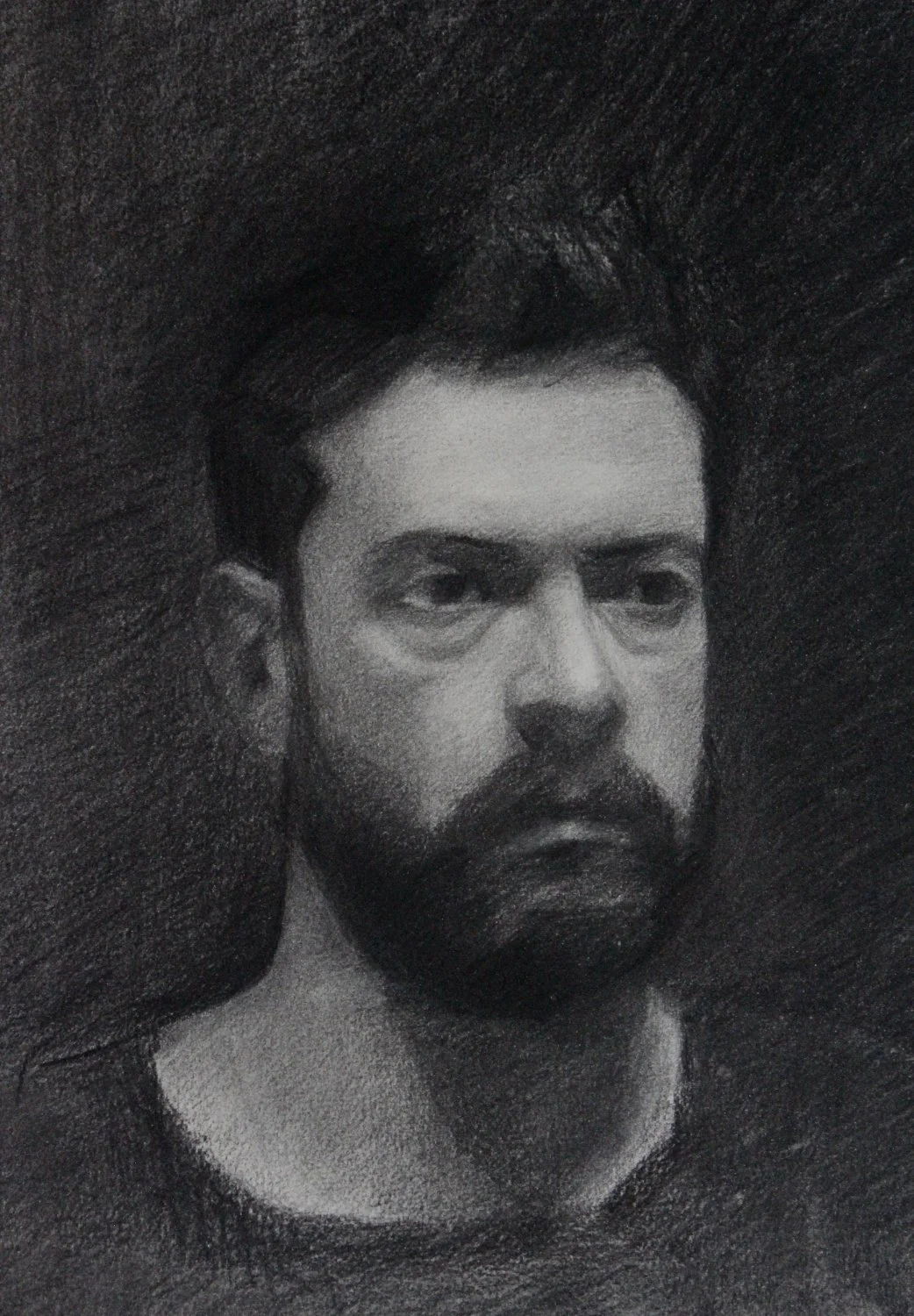 A black and white charcoal drawing of a young man with short, dark hair, closed eyes, and a serious expression, set against a dark textured background.