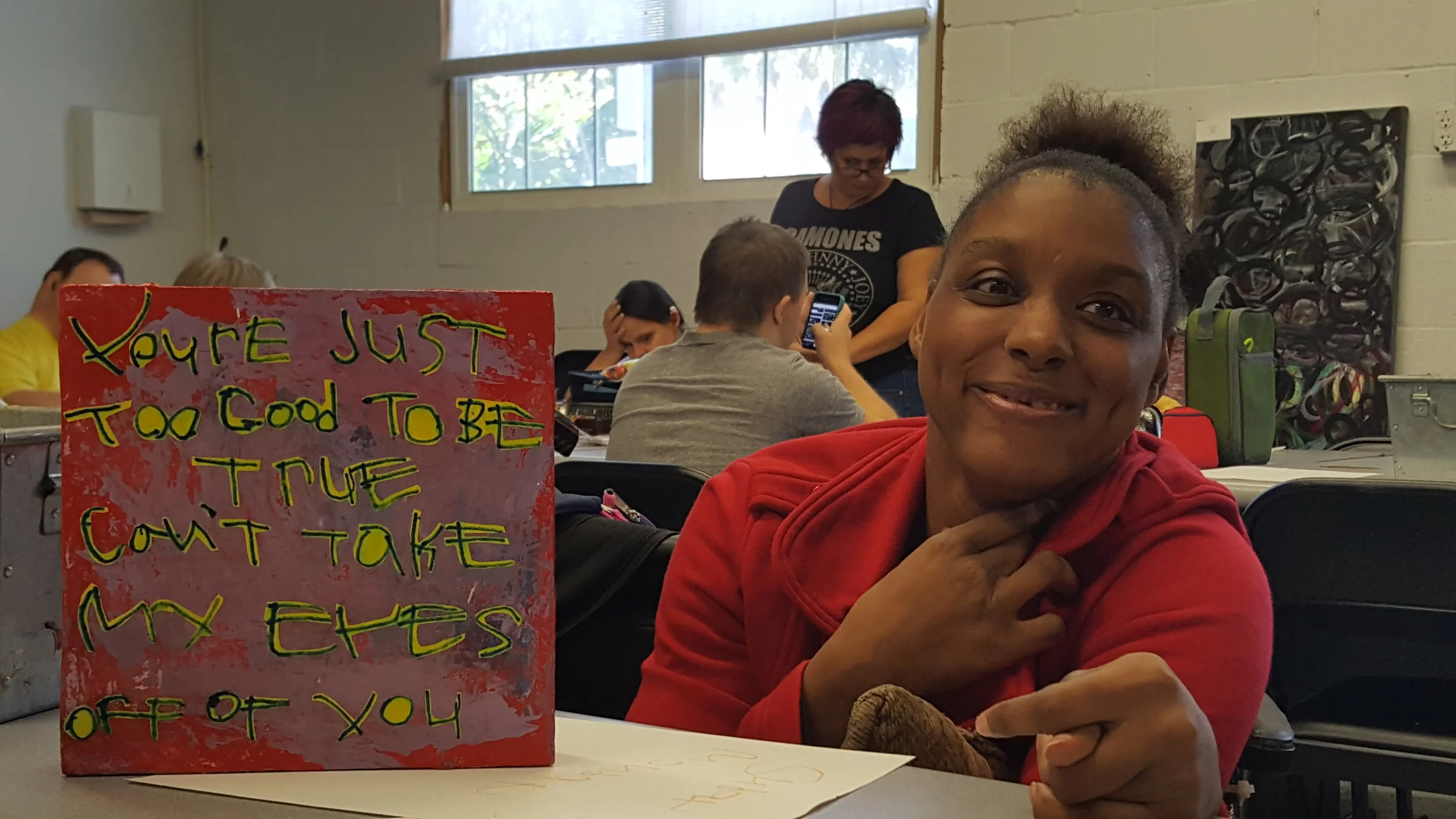 Featured artist Brandy W. with her painting "You're Just too Good to be True."