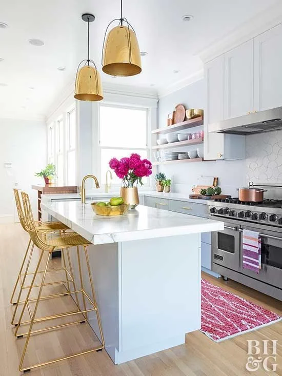 I love a bright and sunny kitchen. A kitchen that gets a lot of natural light is a must for a person who loves to cook, and I do enjoy spending time kitchen trying out new recipes. I am totally obsessed with the gold kitchen stools, the gold kitchen faucet, the gold cabinet hardware, and the fuchsia color pop in the kitchen throw rug and flowers makes this kitchen just a happy place to be. Via