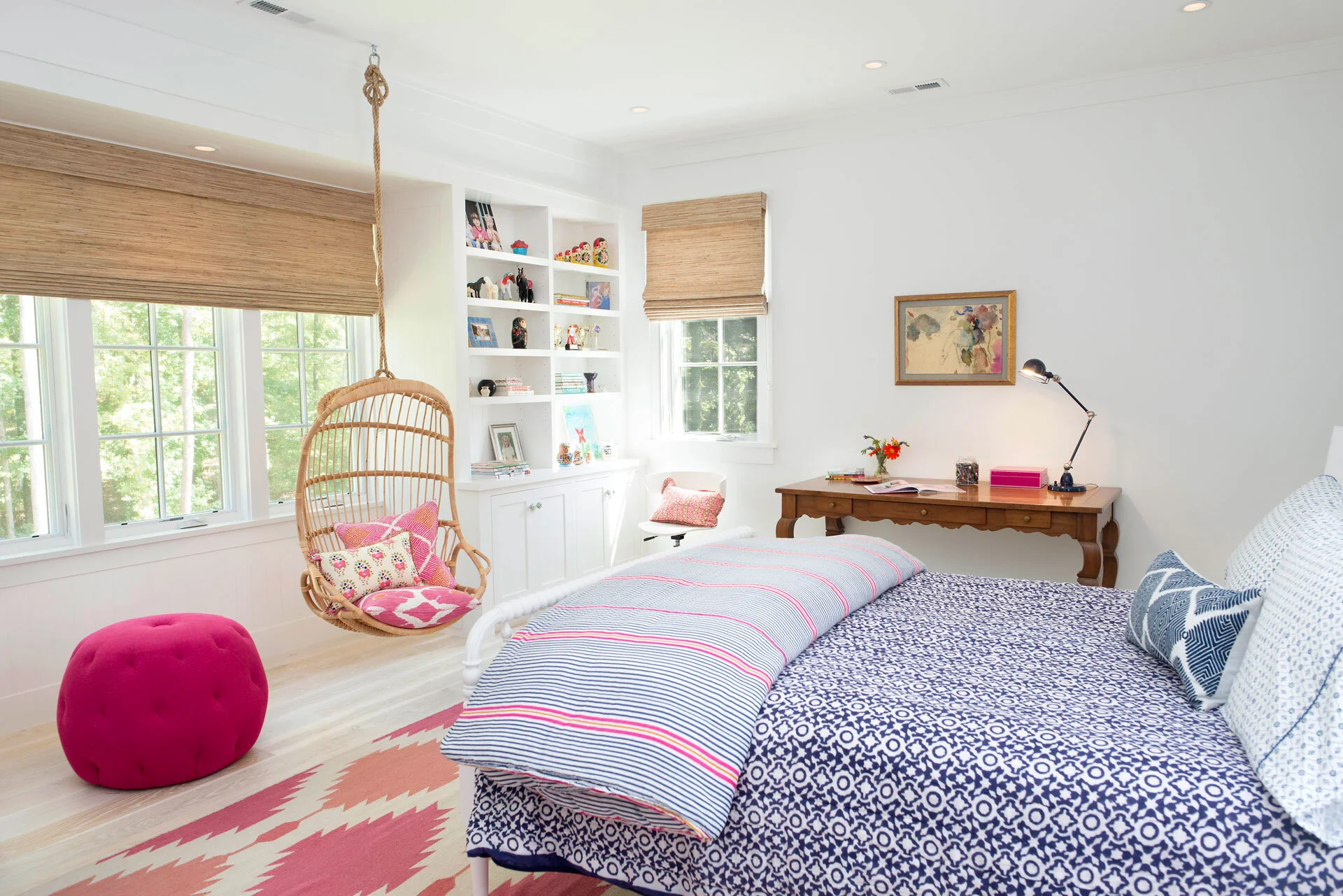 A cheery coastal girl’s bedroom, hanging rattan swing here ,