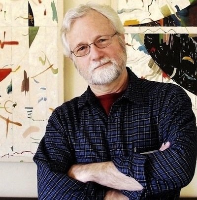 Robert McGowan, standing in front of work by Don Estes featured in the exhibition. Photograph by Truusy Lory.