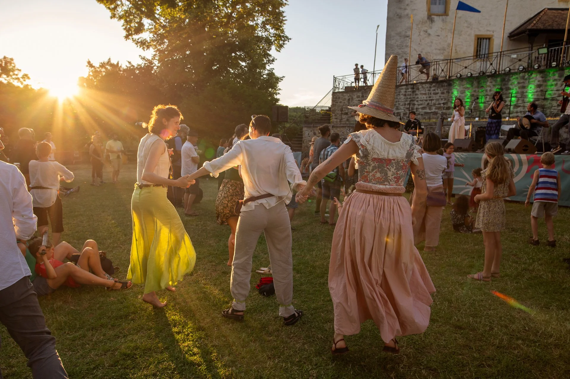 Groupe de personnes lors de la fête médiévale de La Sarraz, devant le château, en plein jour, vêtues de costumes d’époque.