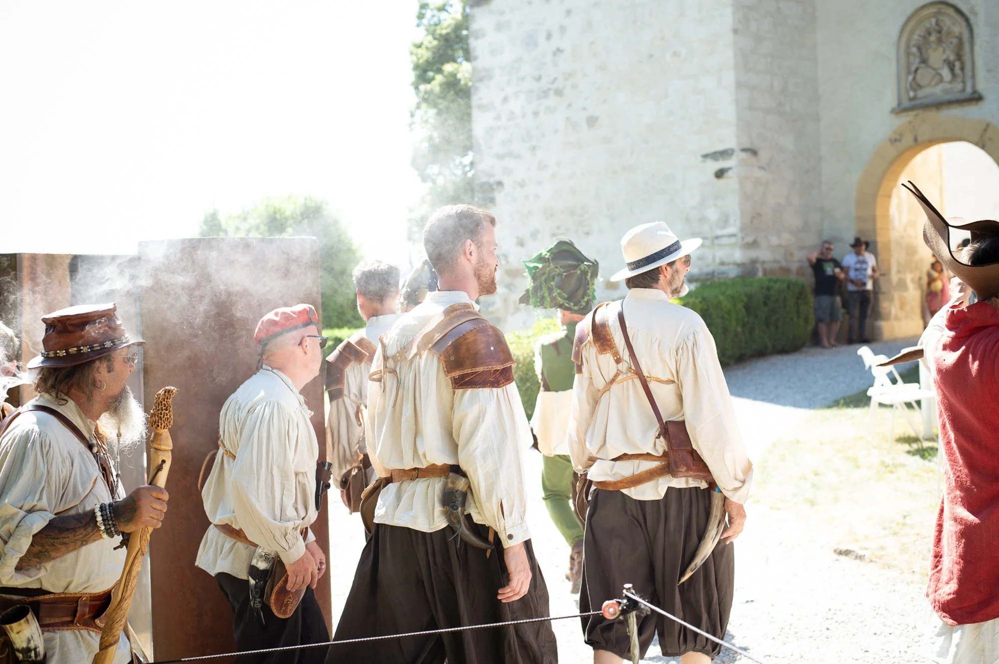Groupe de personnes lors de la fête médiévale de La Sarraz, devant le château, en plein jour, vêtues de costumes d’époque.