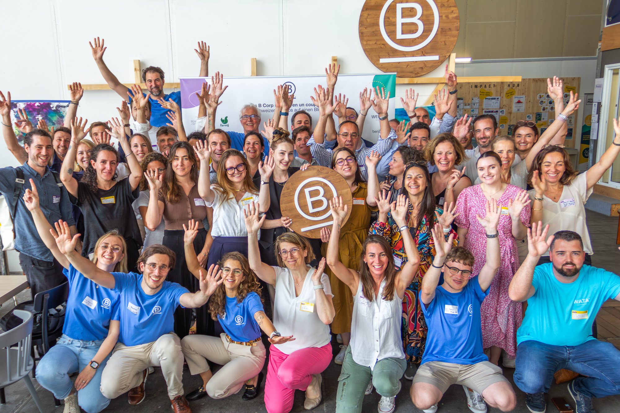 Groupe de personnes, en intérieur, lors d’un événement organisé par B Lab Suisse, avec un fond montrant des affiches et un logo de B Corp.
