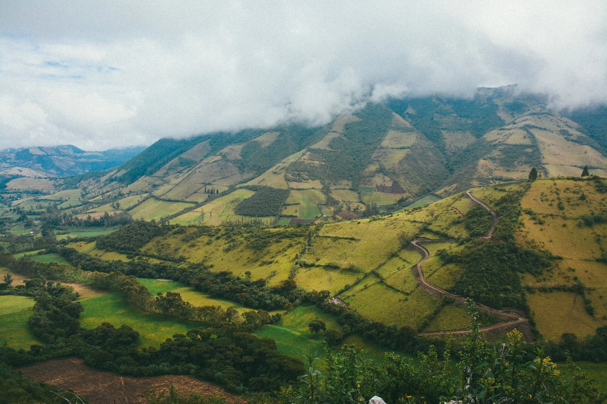 Montagnes et collines cultivées à Nono, Équateur, sous un ciel nuageux.