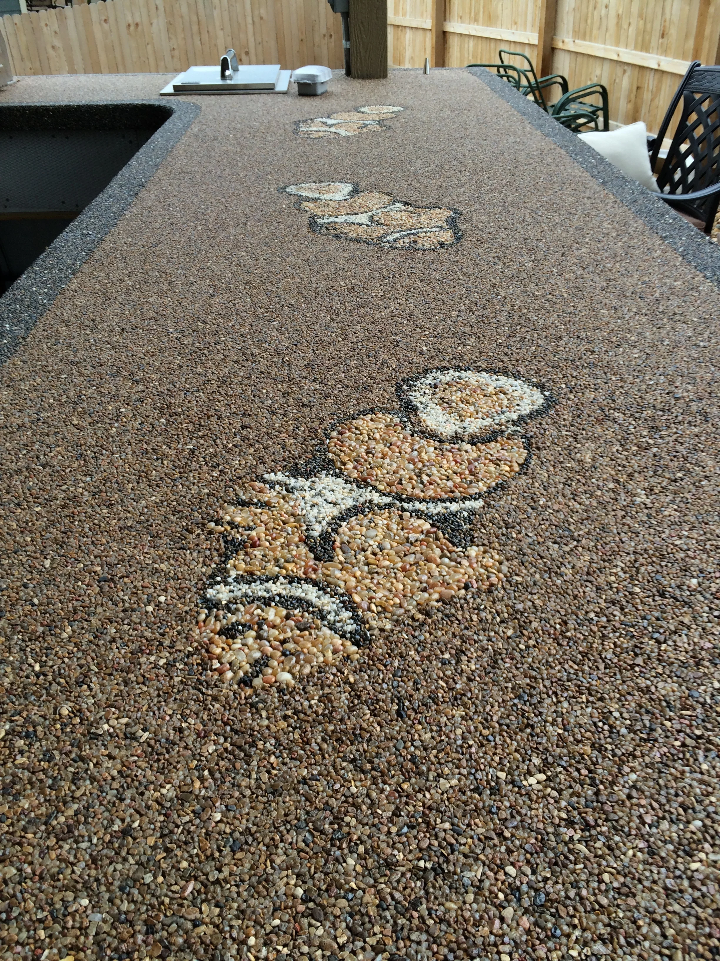 Outdoor kitchen counter surfaced with epoxy rock surface and fish design made of stone..jpeg