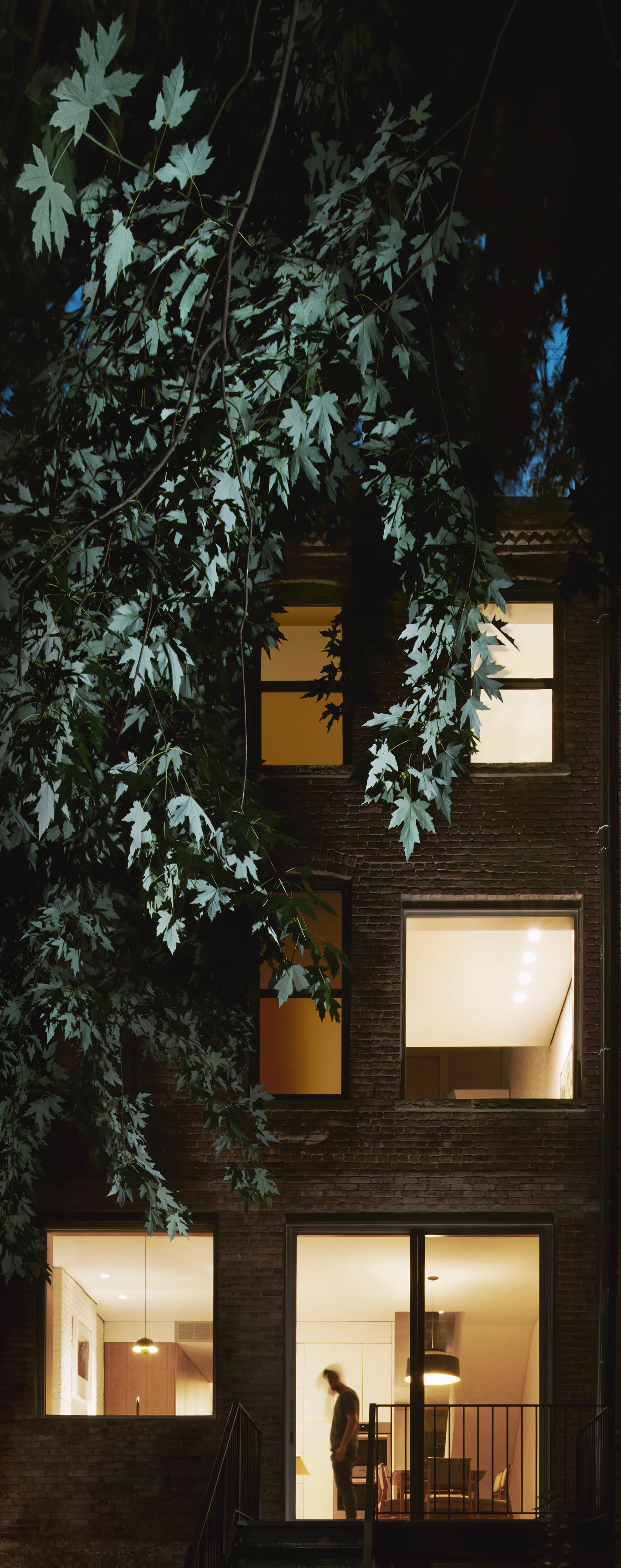 Exterior photo of modern townhouse at night