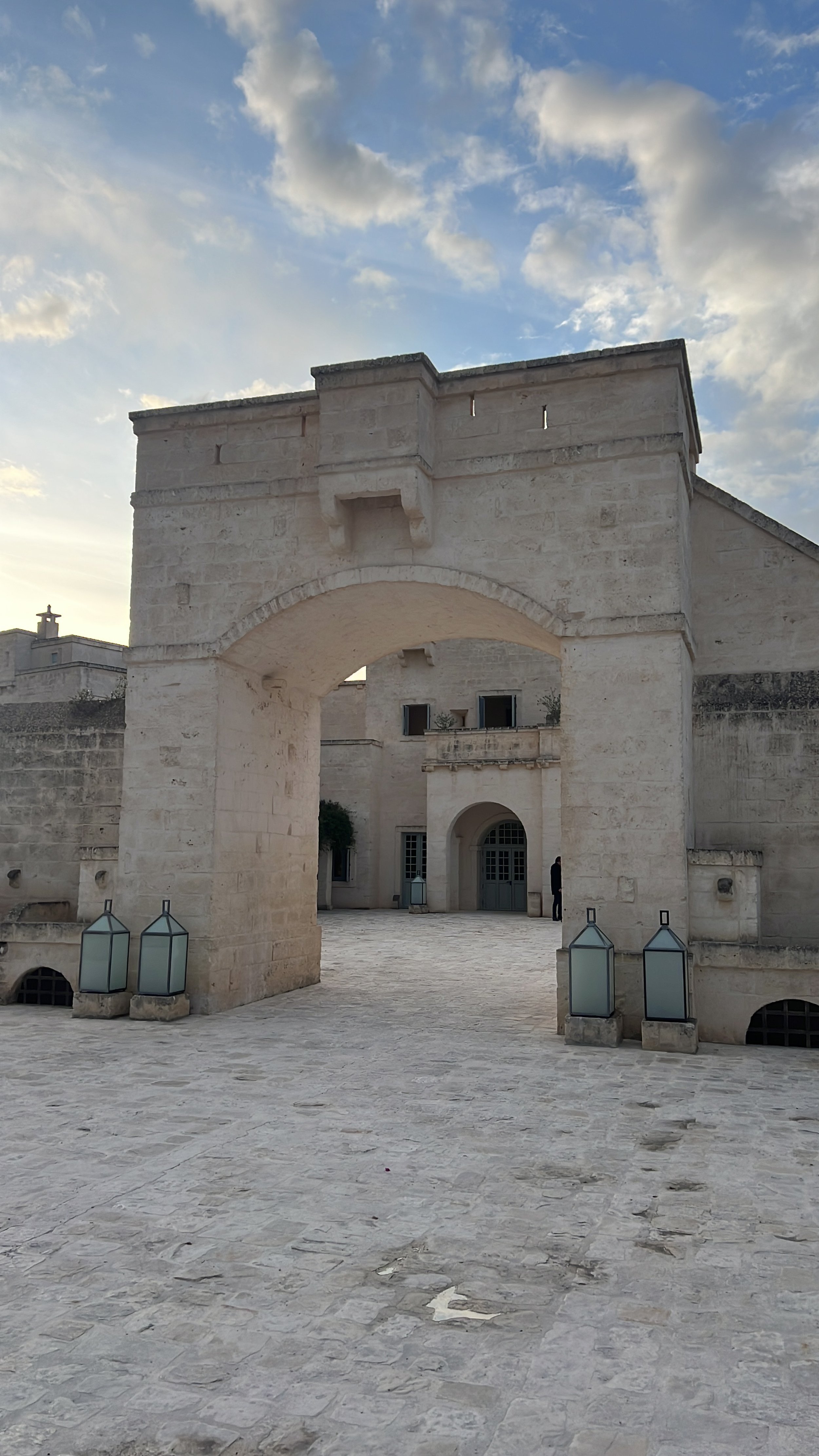 Struttura in pietra con arco, cielo con nuvole in sfondo