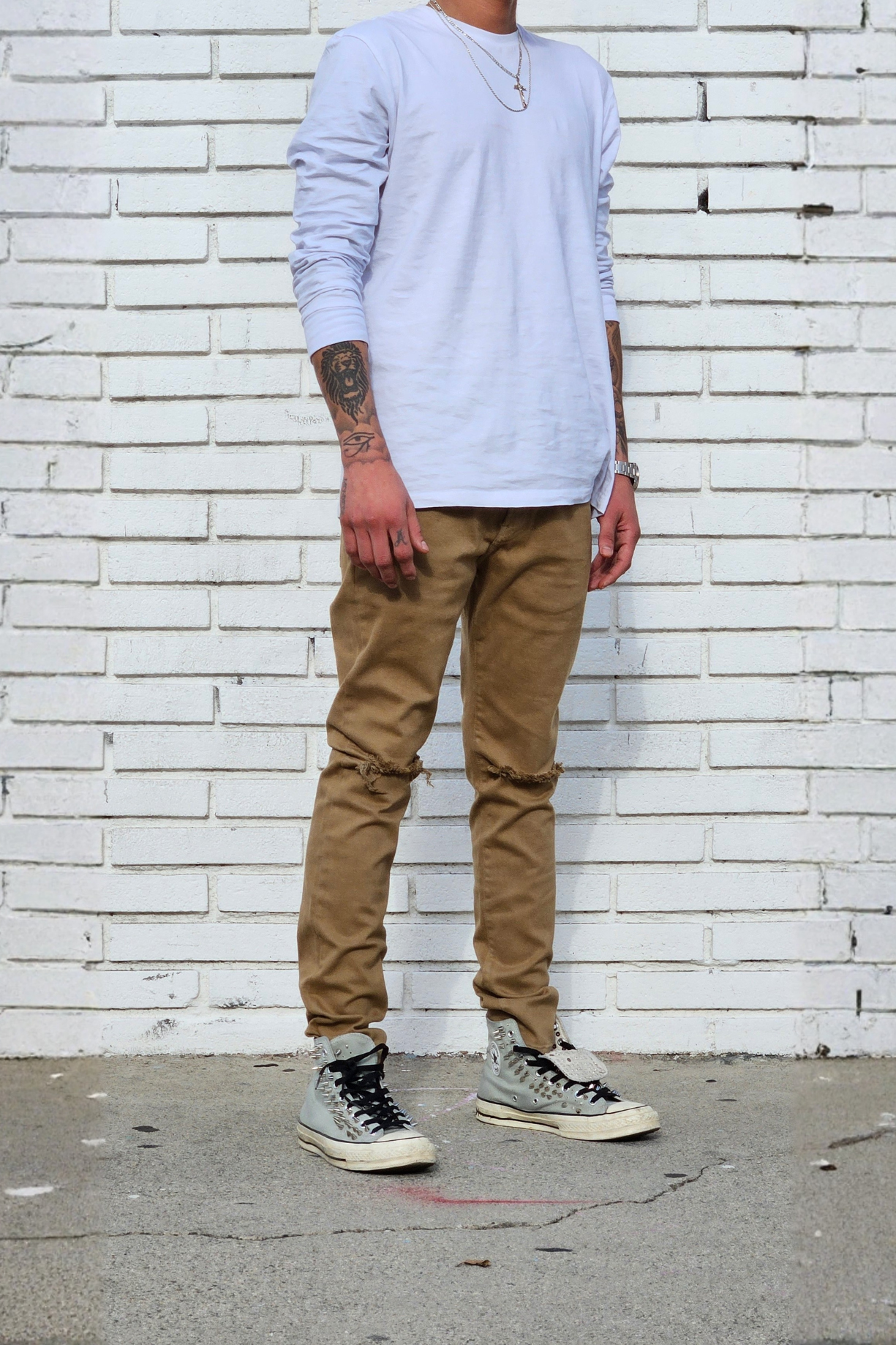 Side view of model in men's knee ripped camel super skinny jeans streetstyle outfit.
