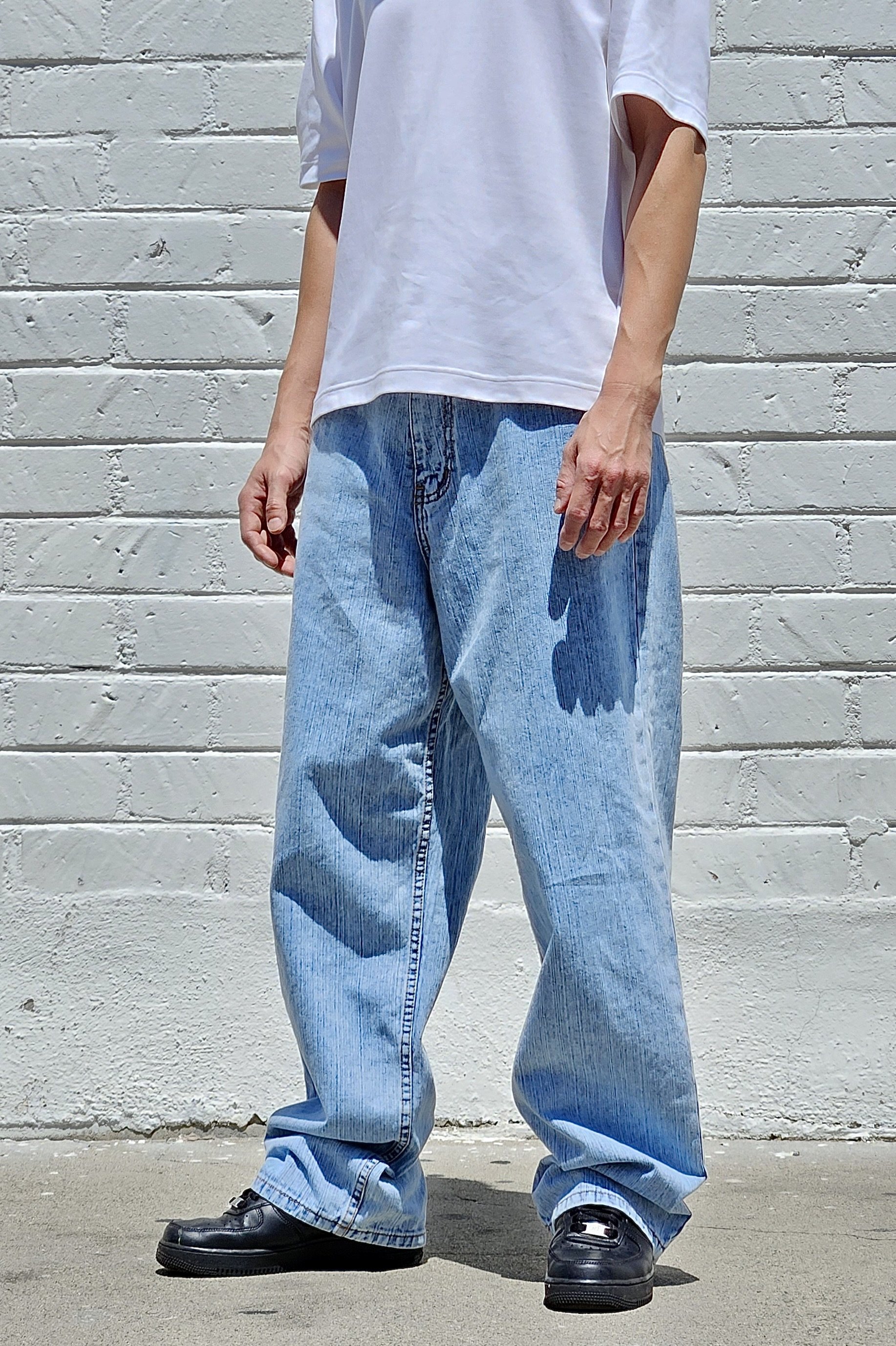 Side view of vertical pastel blue baggy jeans in slub denim.