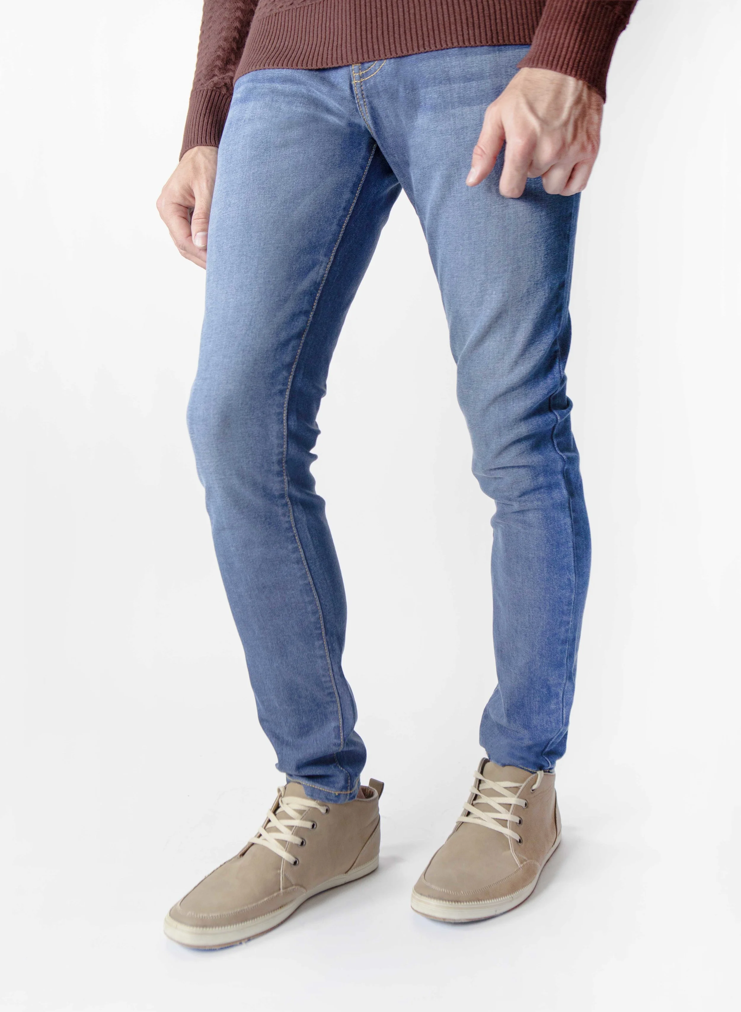 Side view of model in men’s fade medium blue skinny jeans.