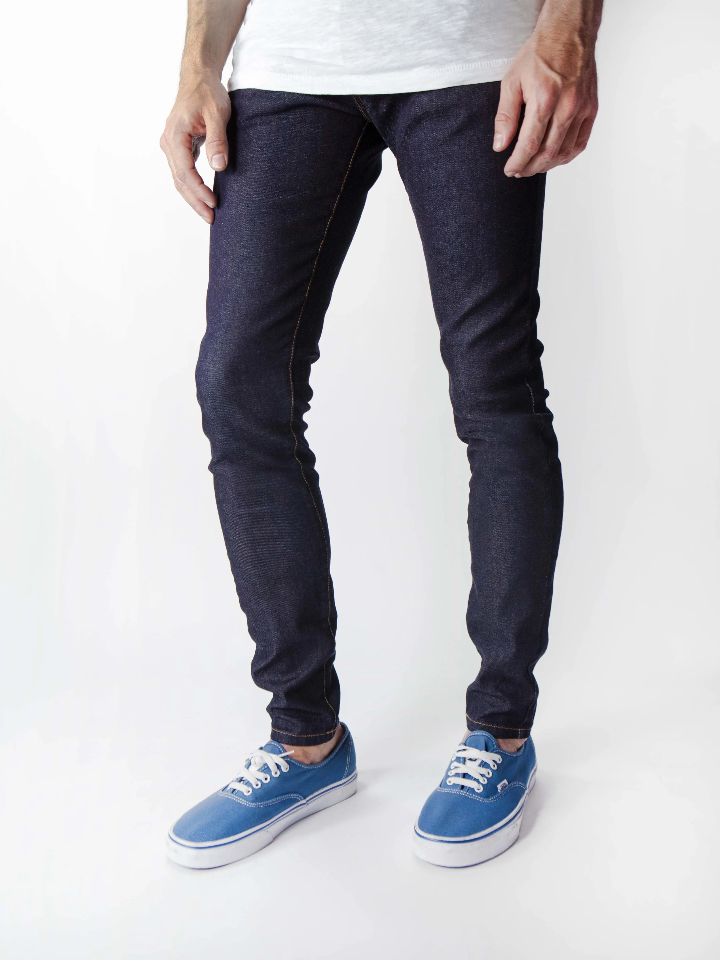 Side view of model in men’s wash super dark skinny jeans.
