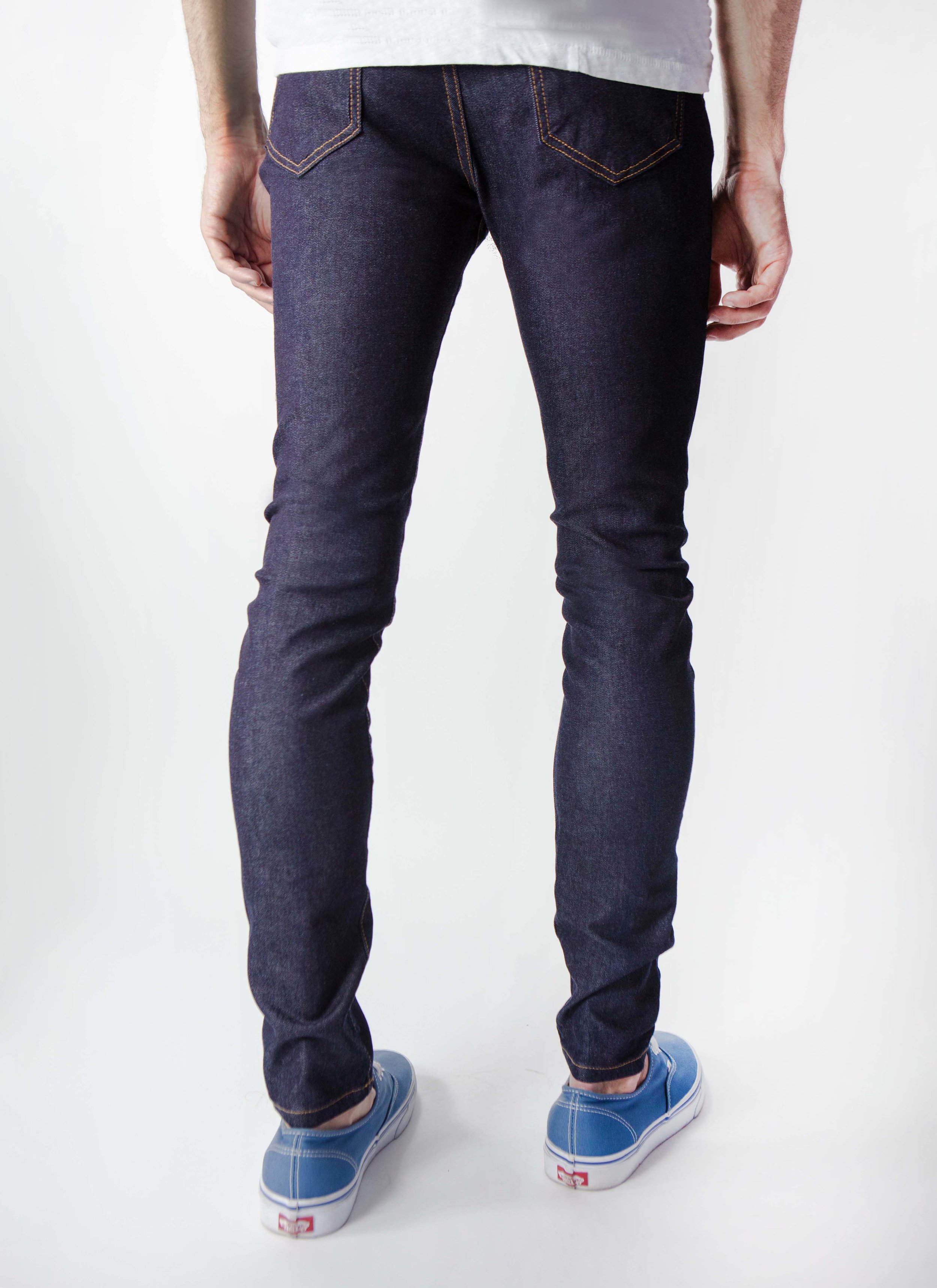 Back view of model in men’s wash super dark skinny jeans.