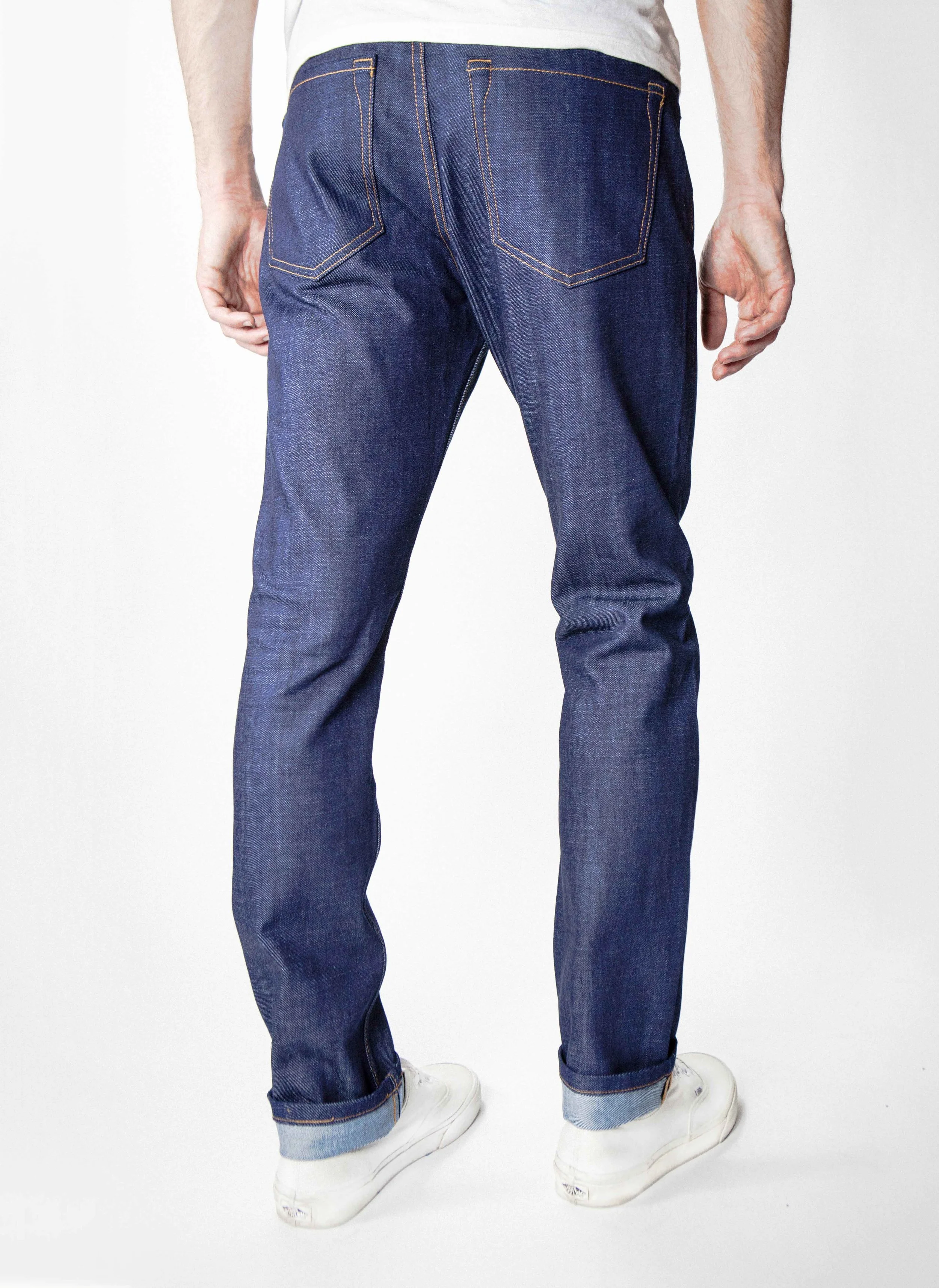 Back view of model in denim blue cross stitch slim straight jeans.