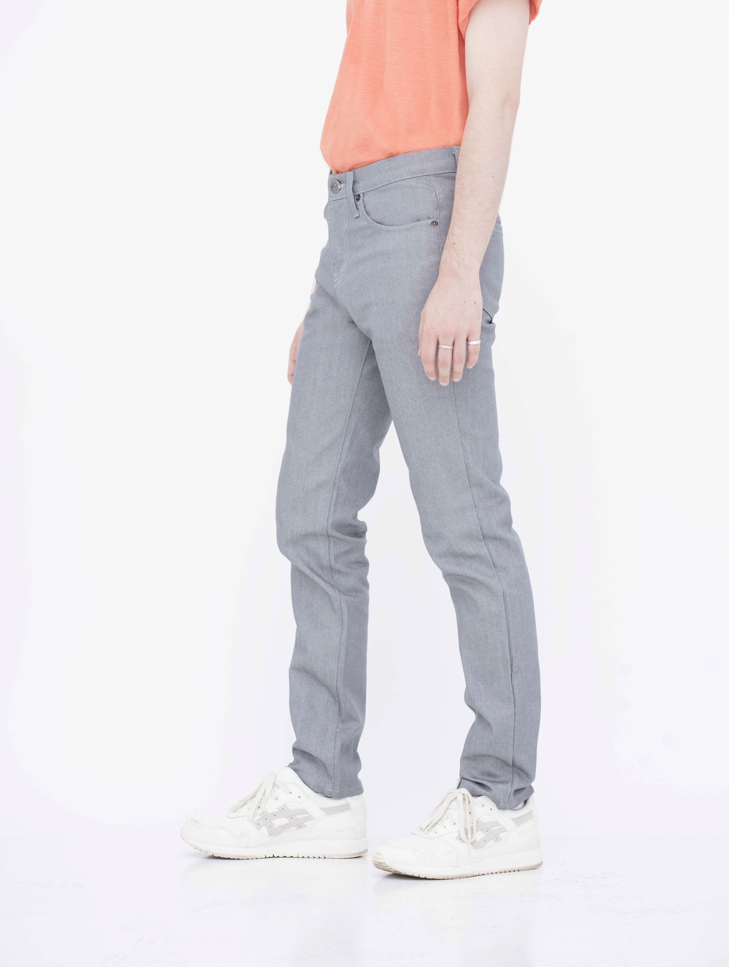 Side view of model in denim light grey jeans.