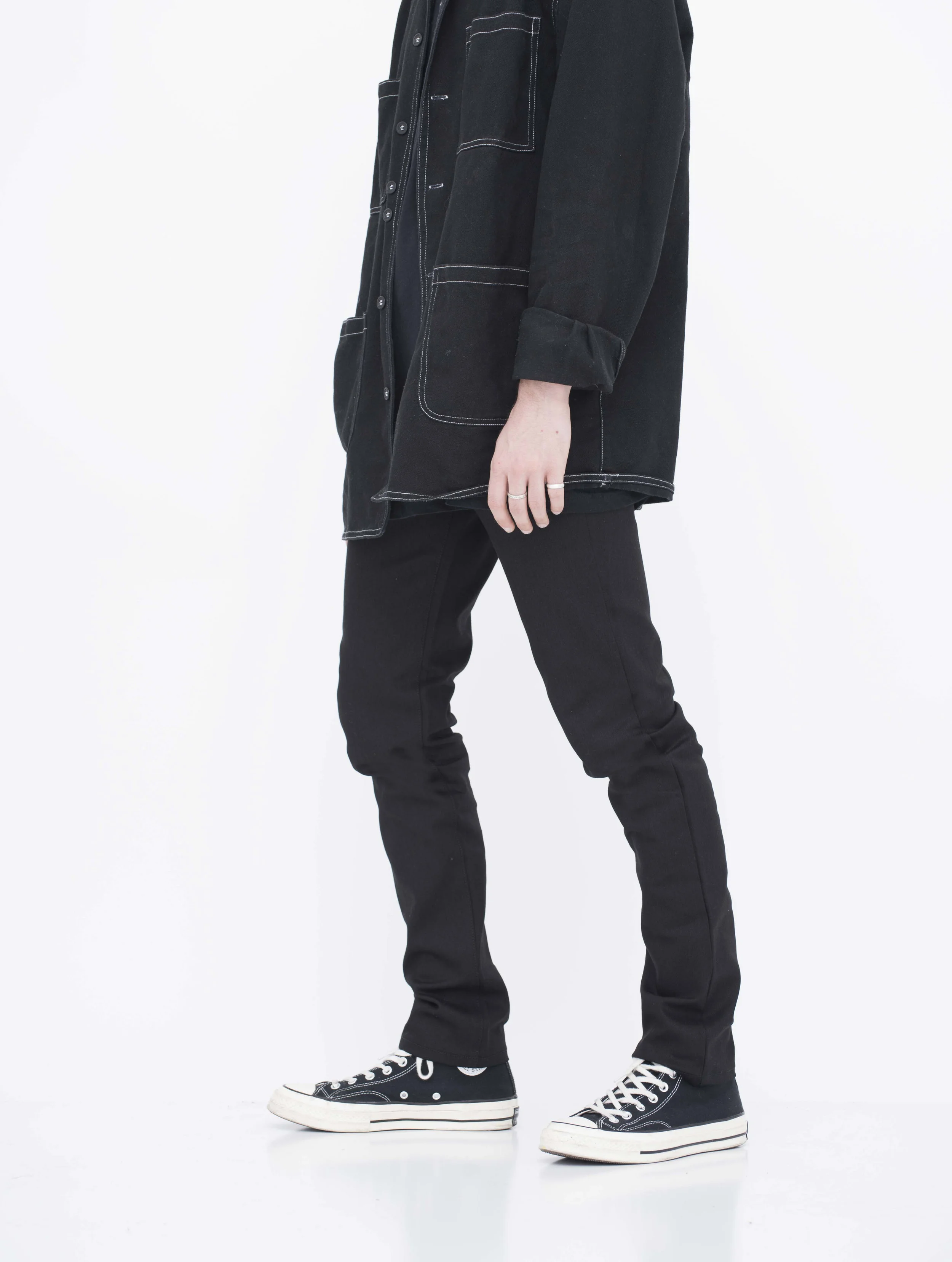 Side view of model in shiny black skinny jeans.
