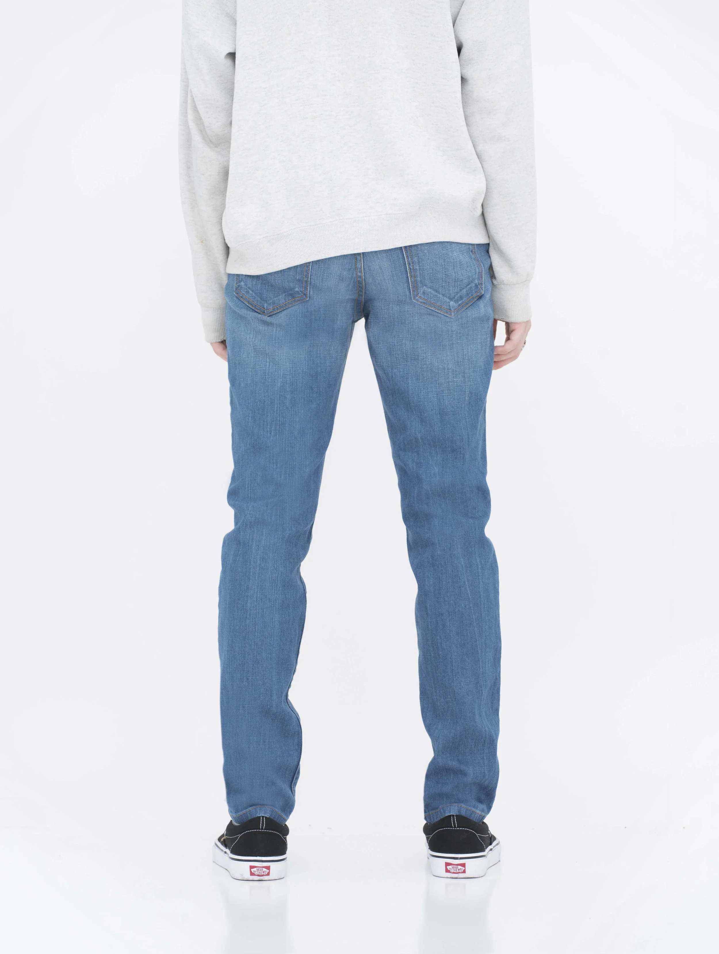 Back view of model in fade medium blue skinny jeans.